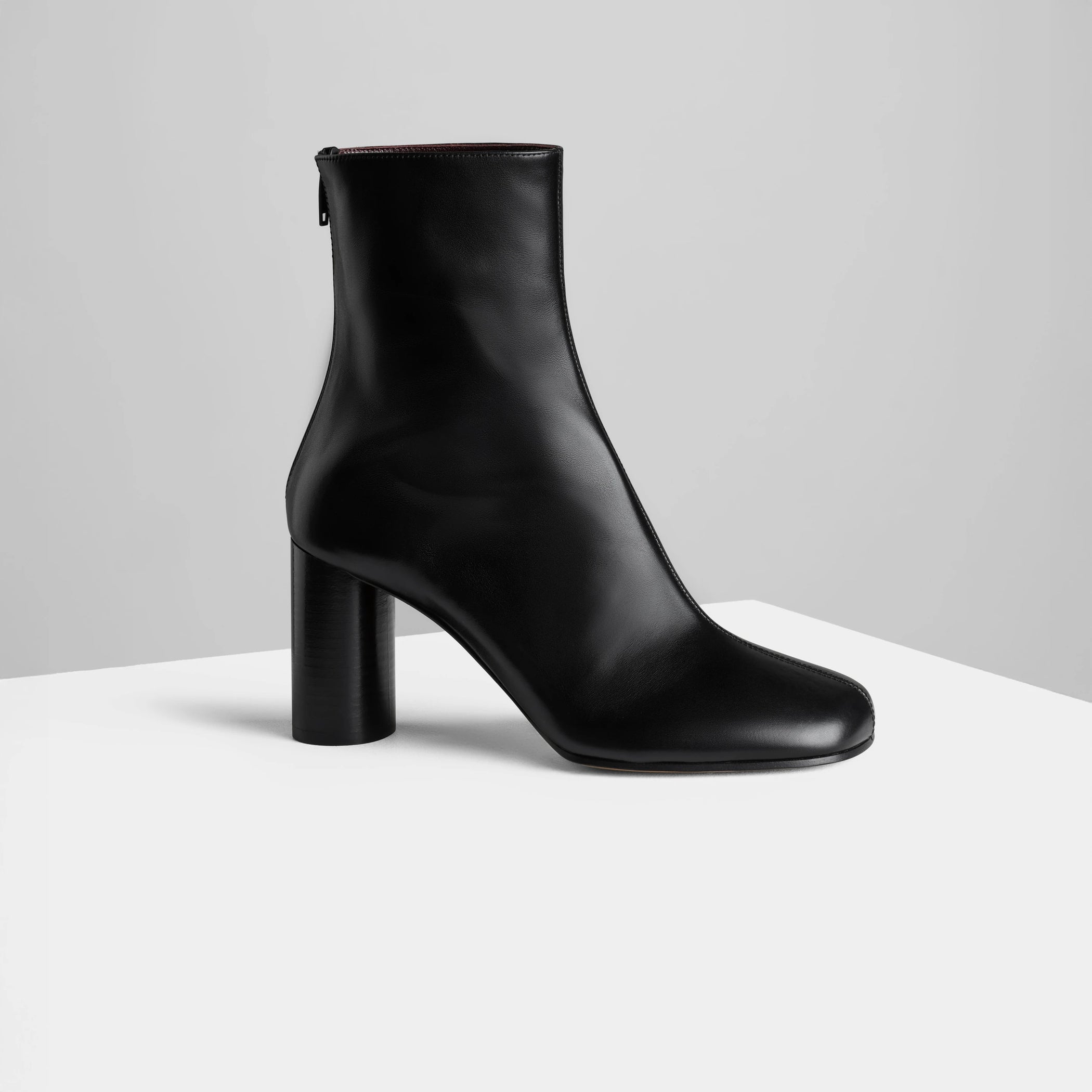Side view of tug ankle boot in black leather.