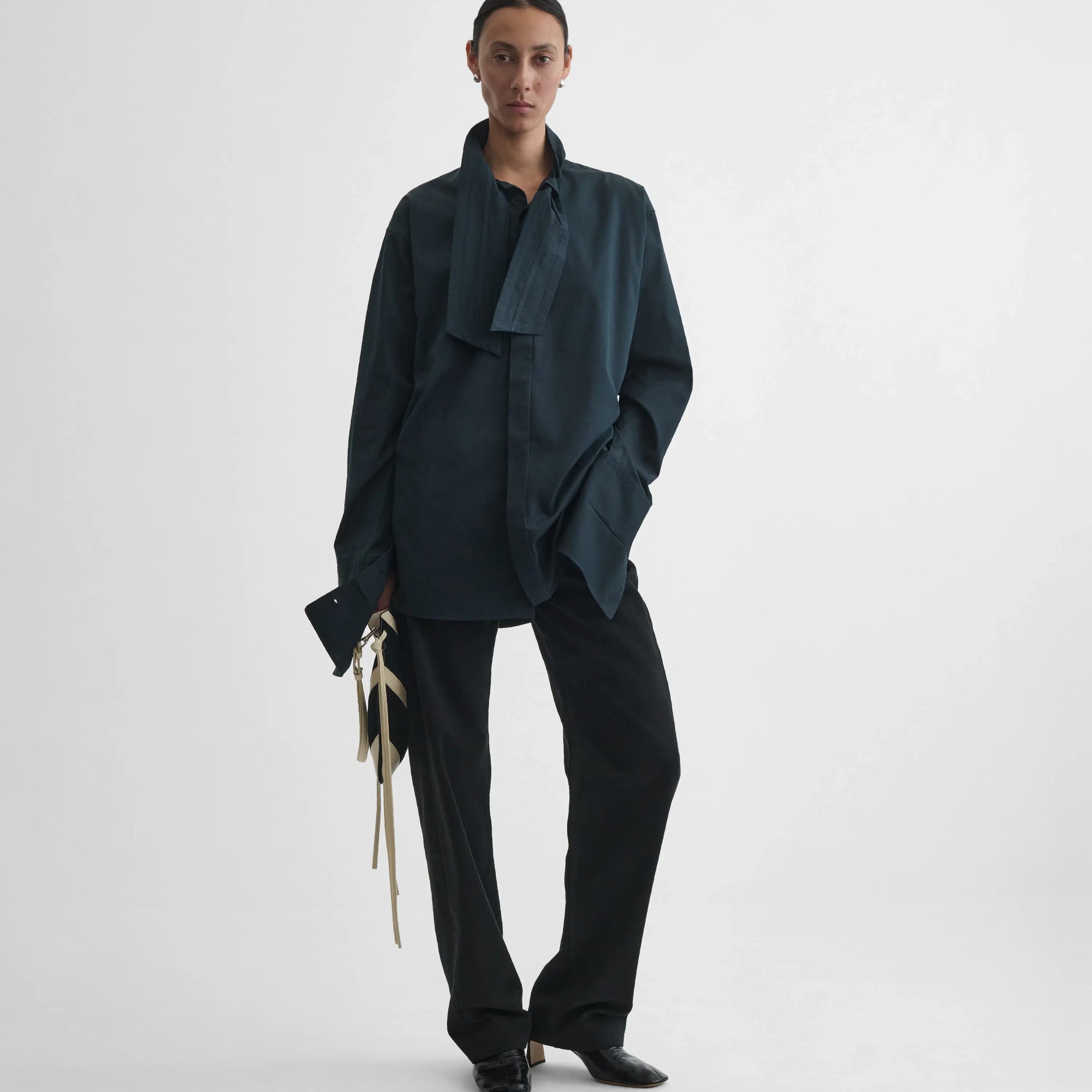 Full body front view of model wearing Tie Neck Shirt in midnight.