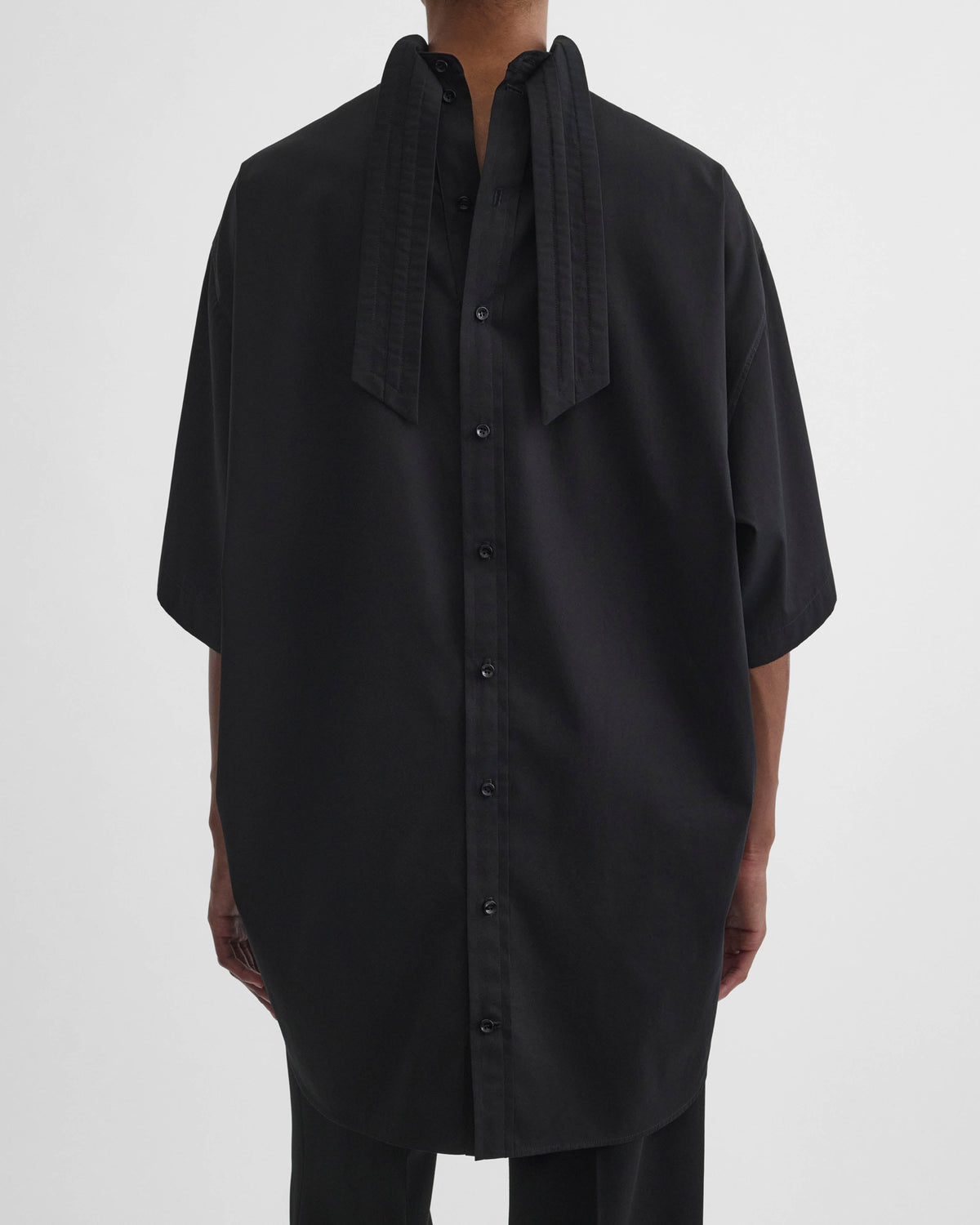 Back view of model wearing TIE NECK SHORT SLEEVE SHIRT in black cotton