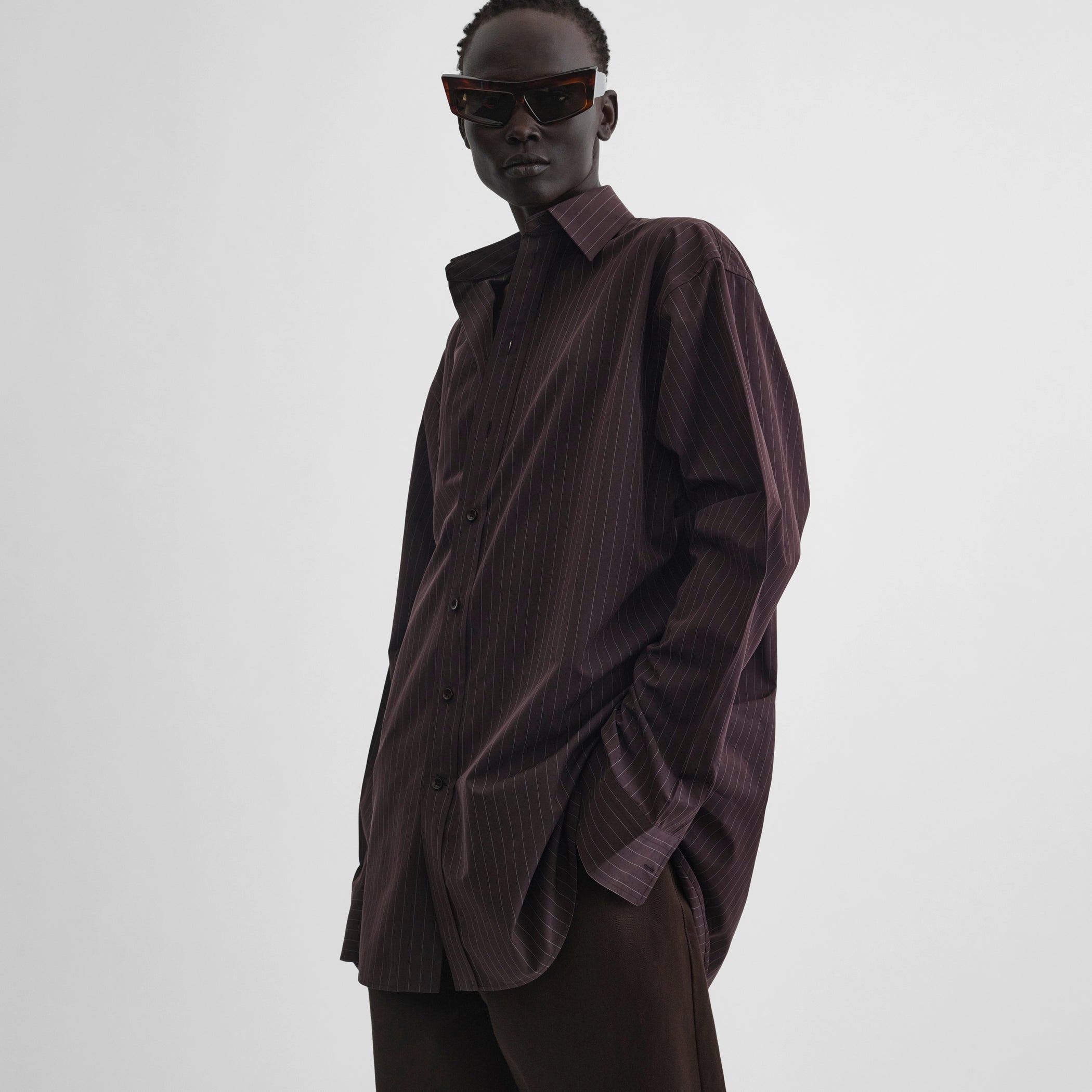 Angled front view of model wearing sharp collar shirt in black cherry pinstripe cotton