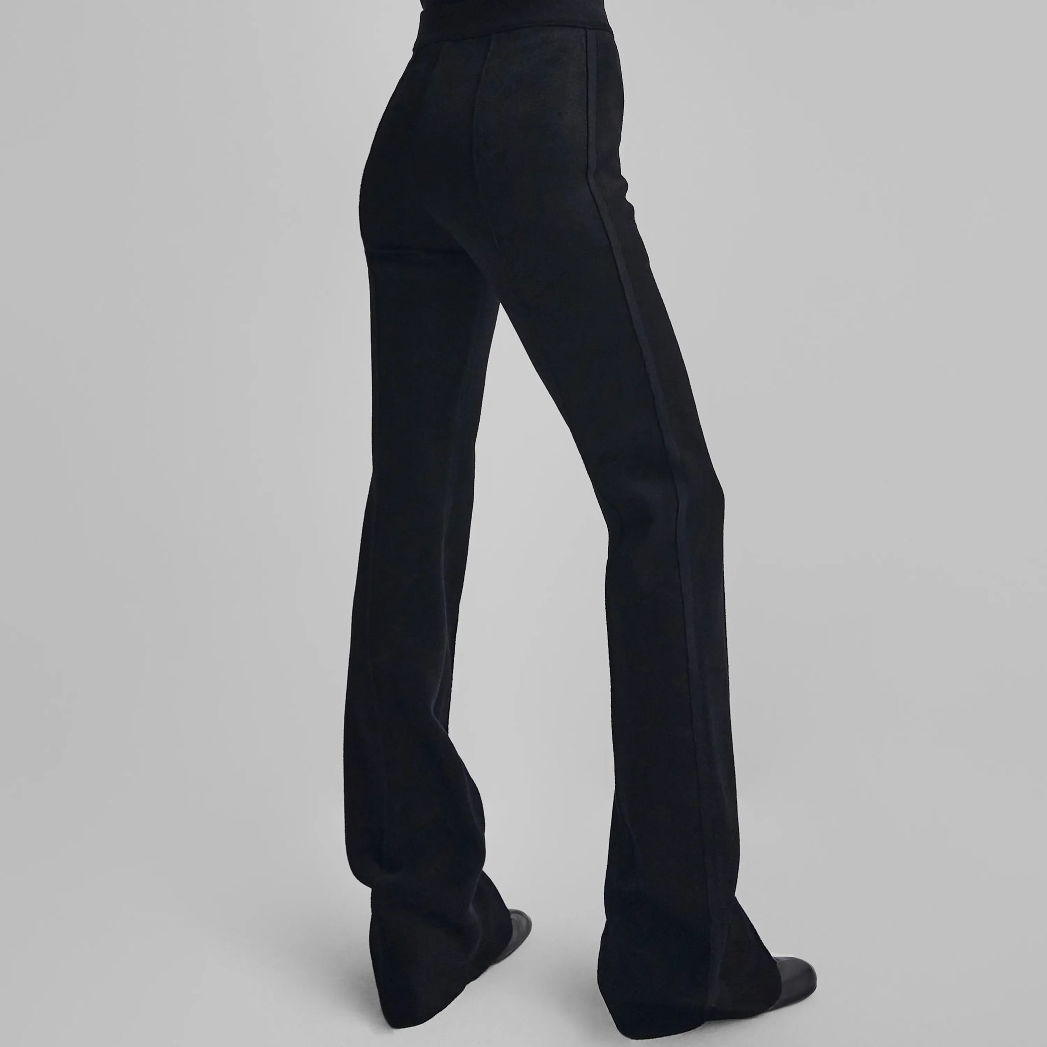Back view of model wearing CHENILLE TROUSERS in black technical polyester