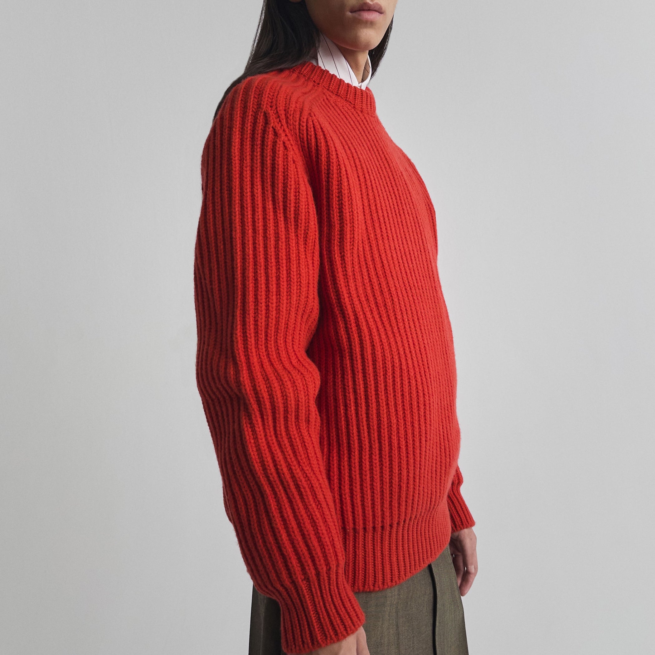 Side view of model wearing CREW-NECK JUMPER in bright red english rib cashmere