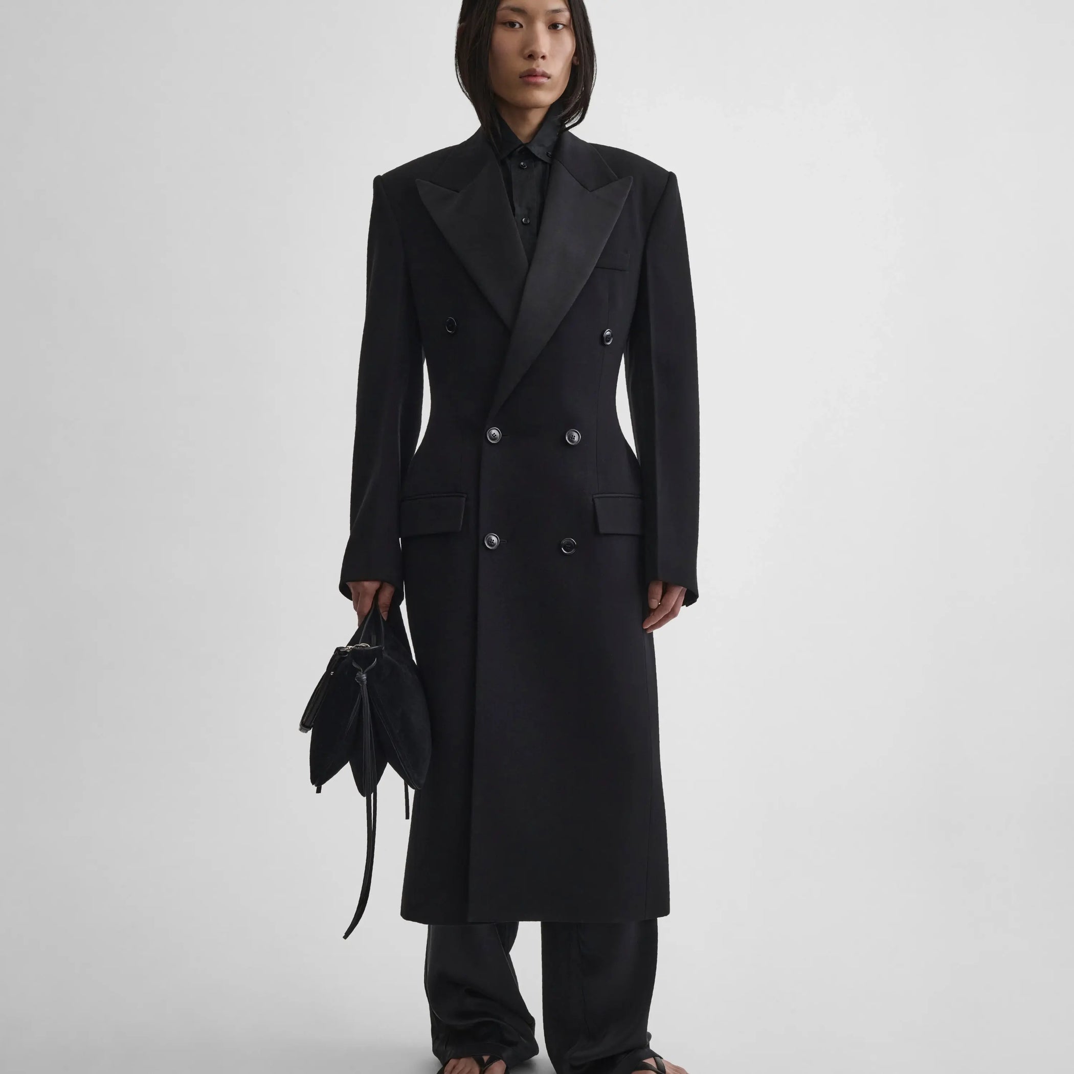 Front full length view of model wearing Tailored Coat With Dropped Waist in black.