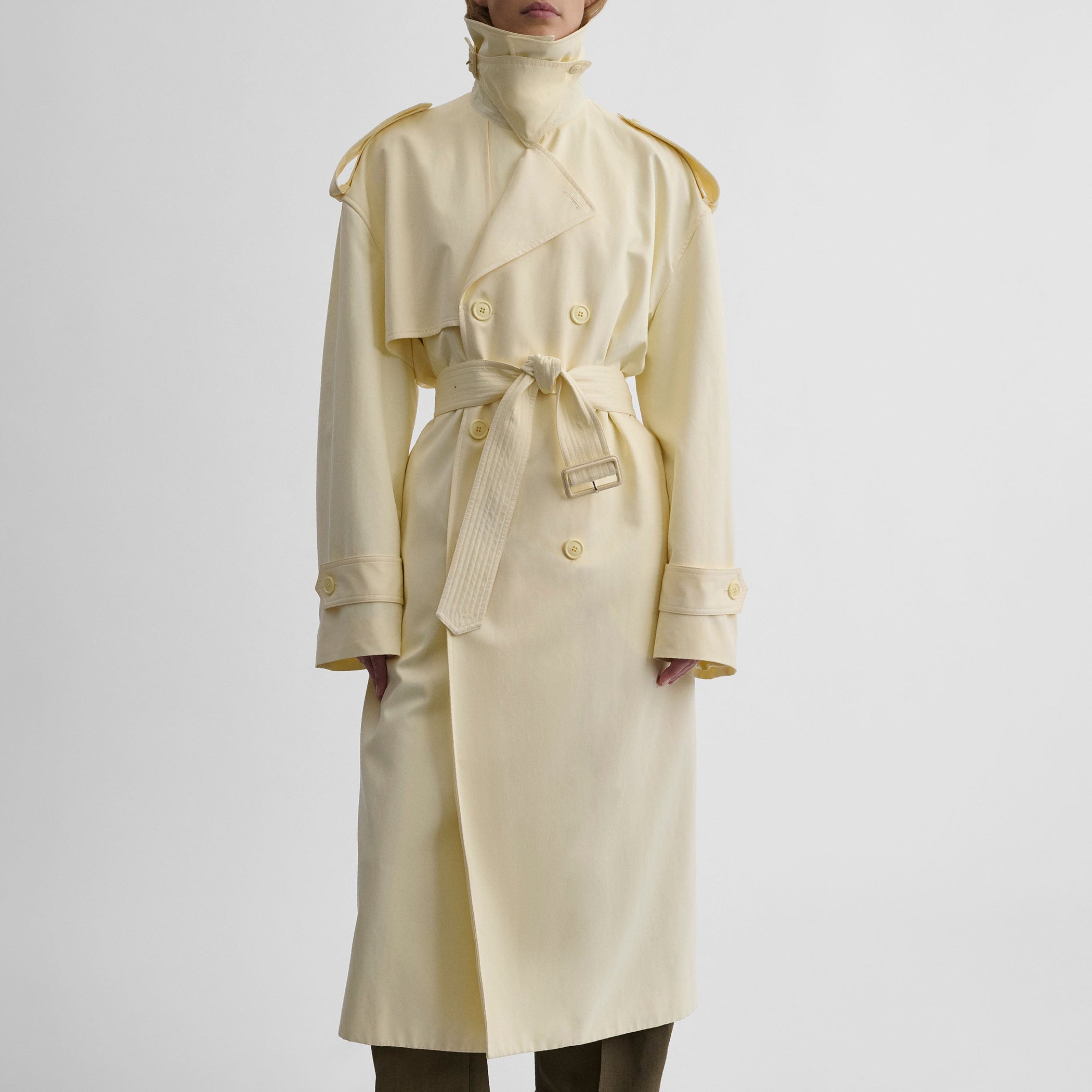 Front view of model wearing TRENCH COAT WITH ATTACHABLE SCARF in cream technical polyester