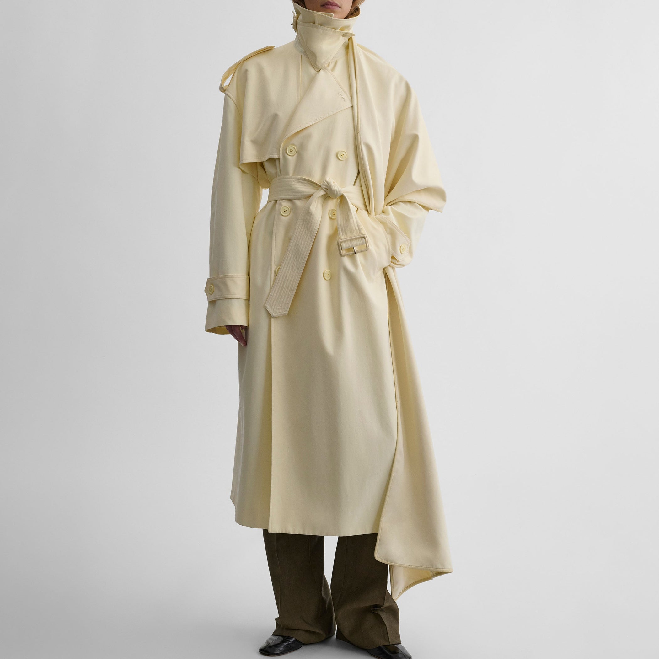 Front view of model wearing TRENCH COAT WITH ATTACHABLE SCARF in cream technical polyester