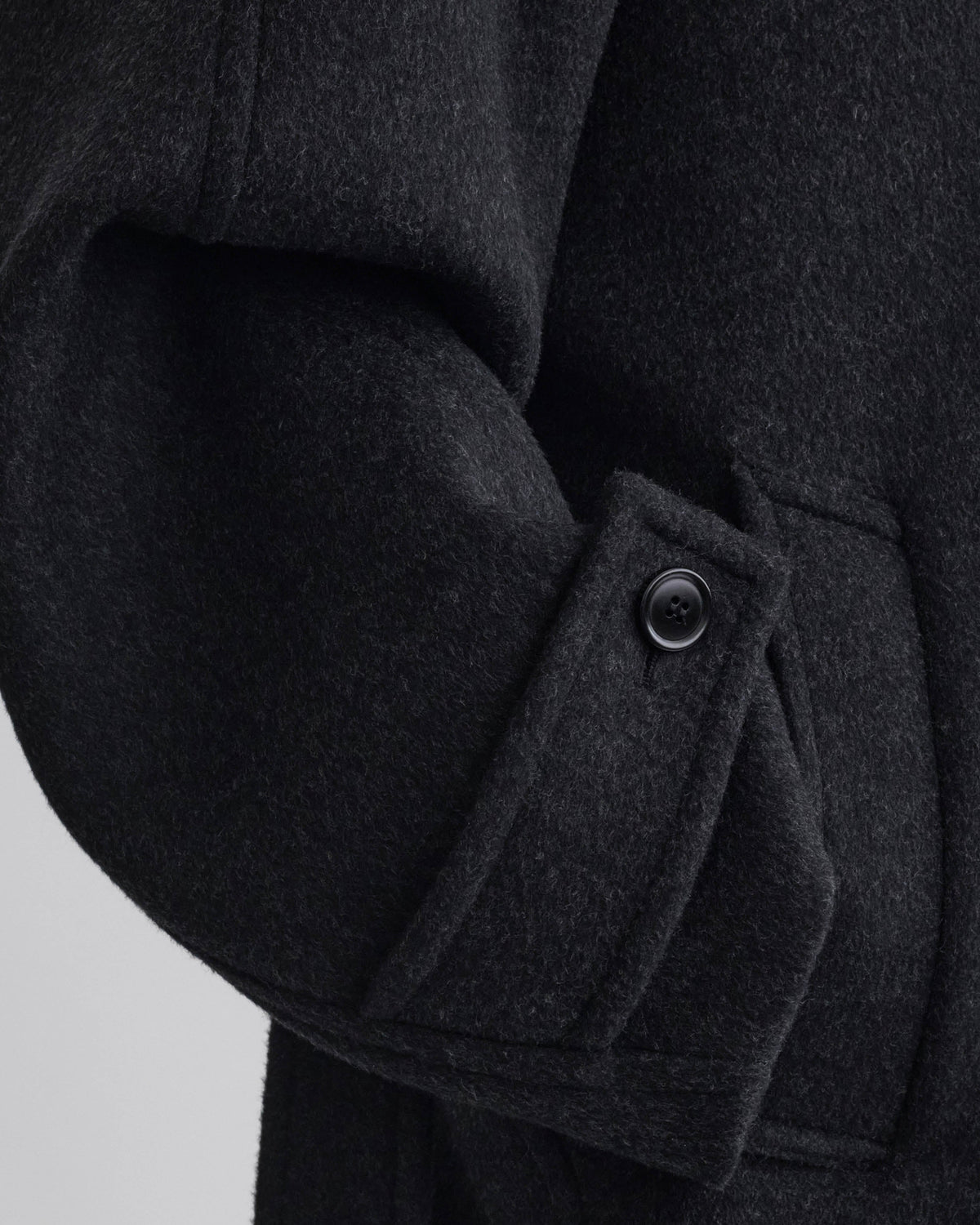 Detail view of model wearing ROUNDED SHOULDER COAT in anthracite wool cashmere
