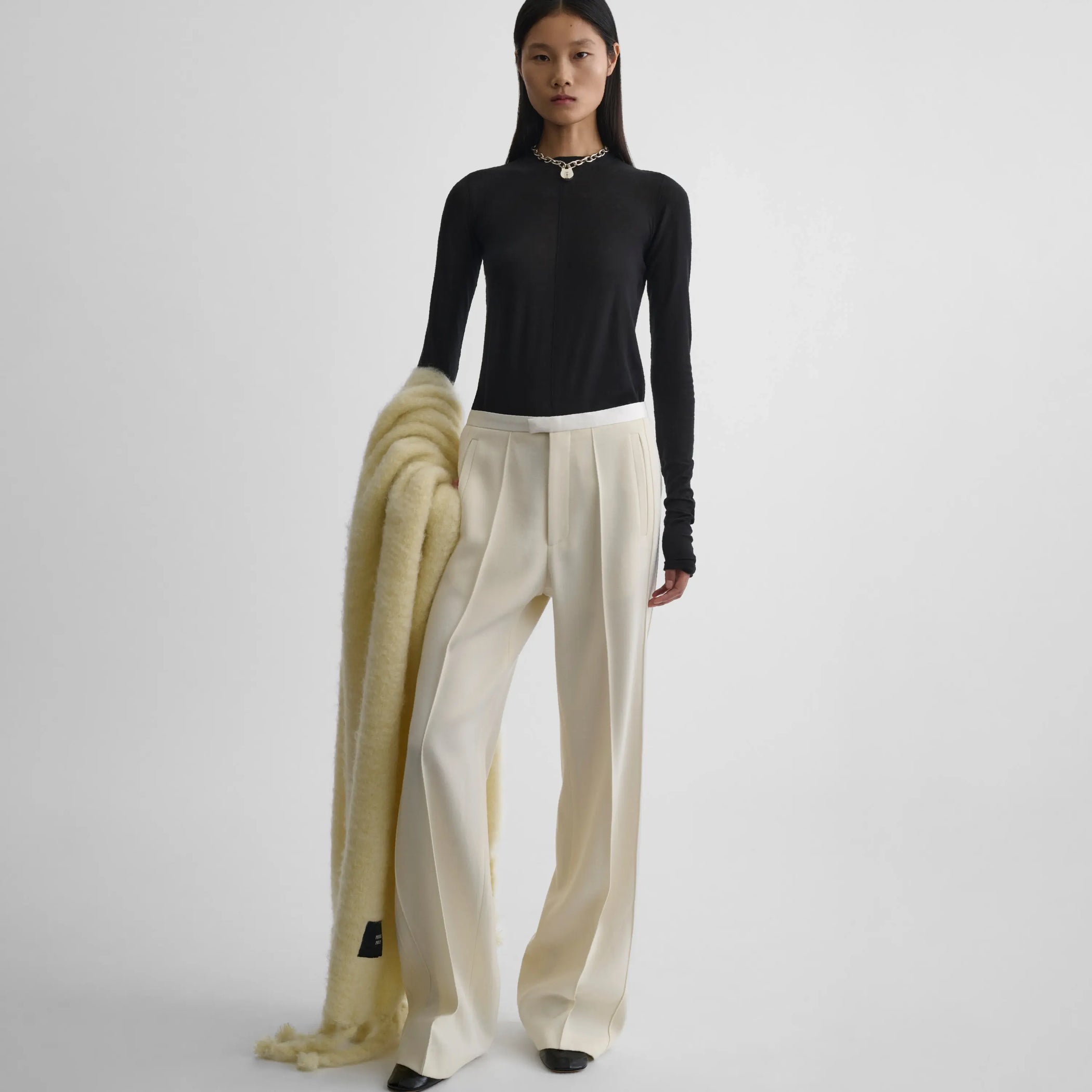 Front view of model wearing Classic Tailored Trousers in cream.