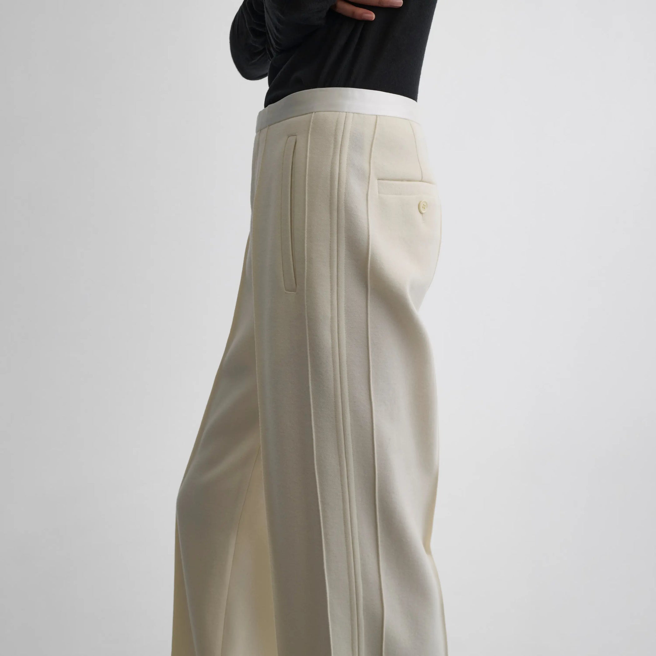 Side view of model wearing Classic Tailored Trousers in cream.