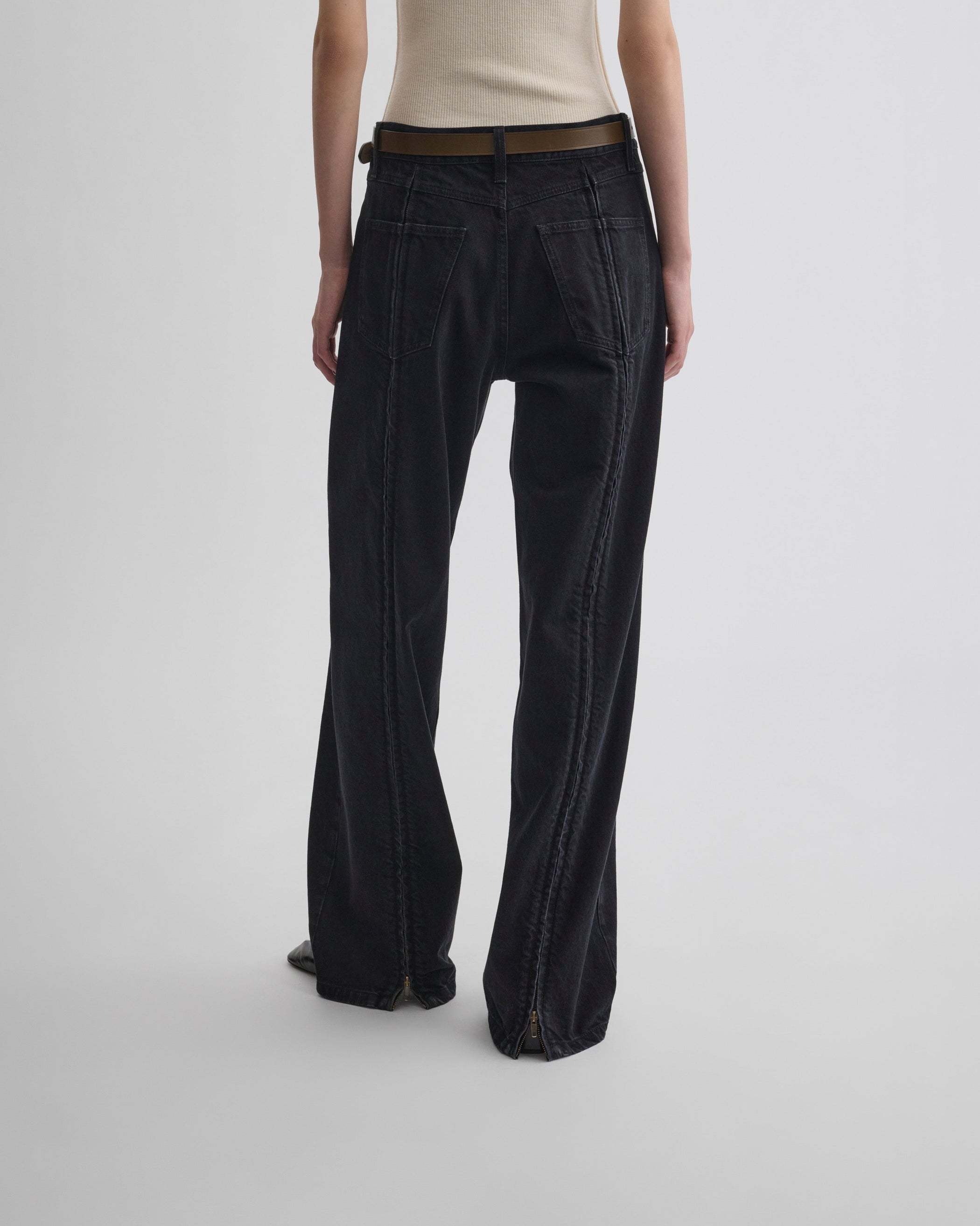 Back view of model wearing ZIP JEANS in black cotton