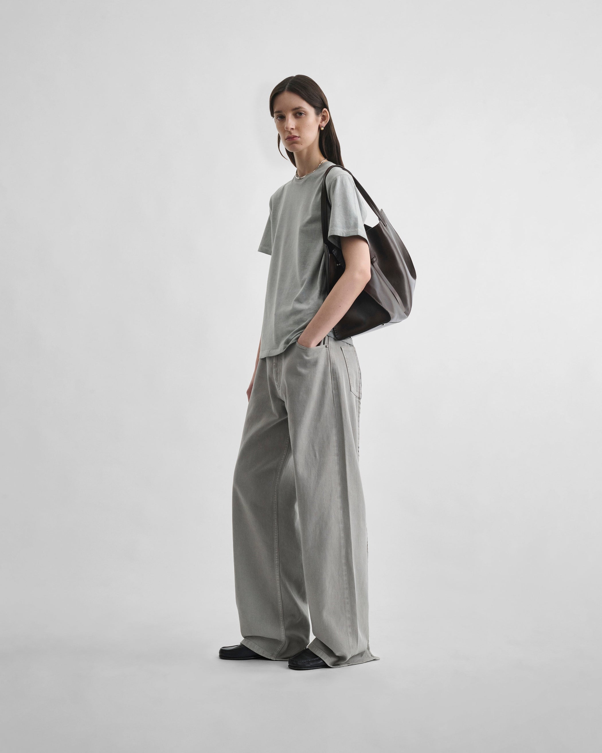 Angled front view of model wearing ZIP JEANS in ash grey cotton