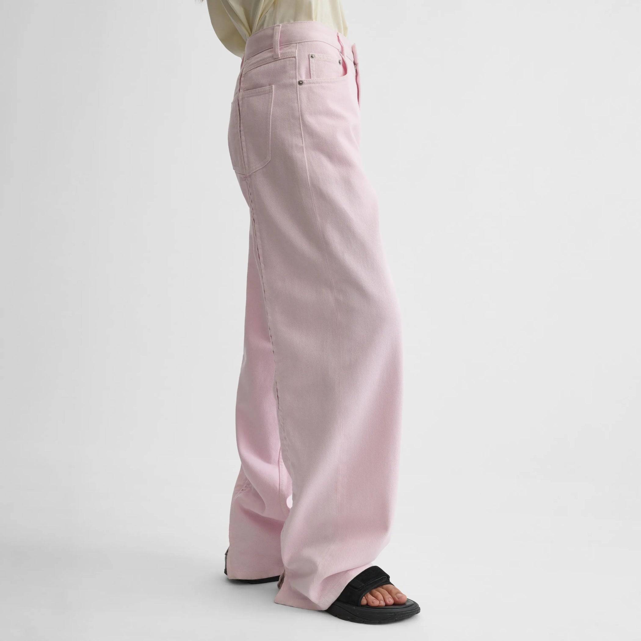 Side view of zip jeans in pale pink cotton