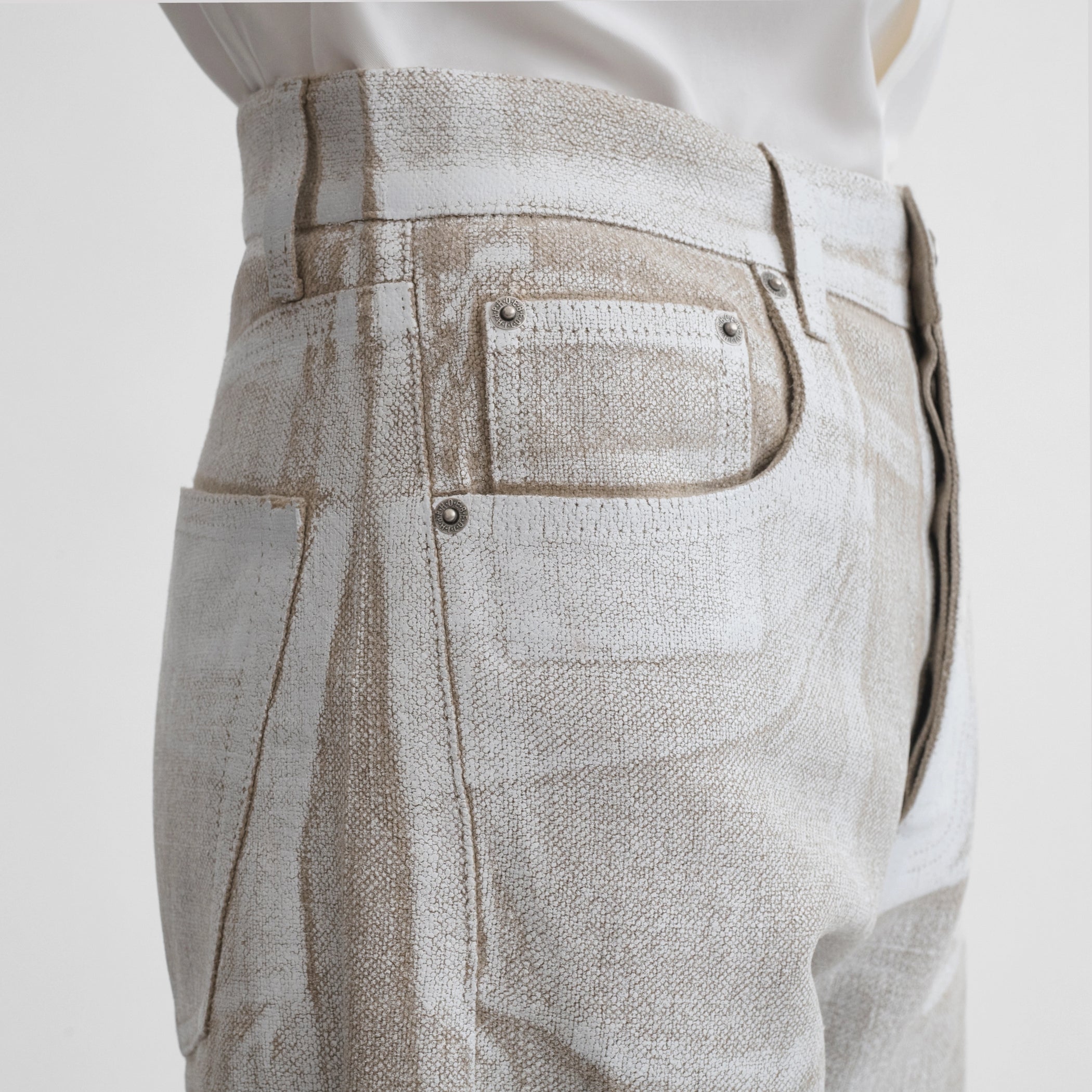 Side close up view of model wearing the classic jeans in hay