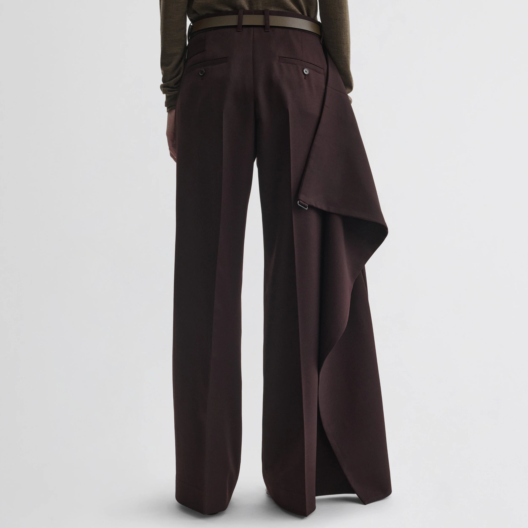 Back view of model wearing apron trousers in chocolate wool.