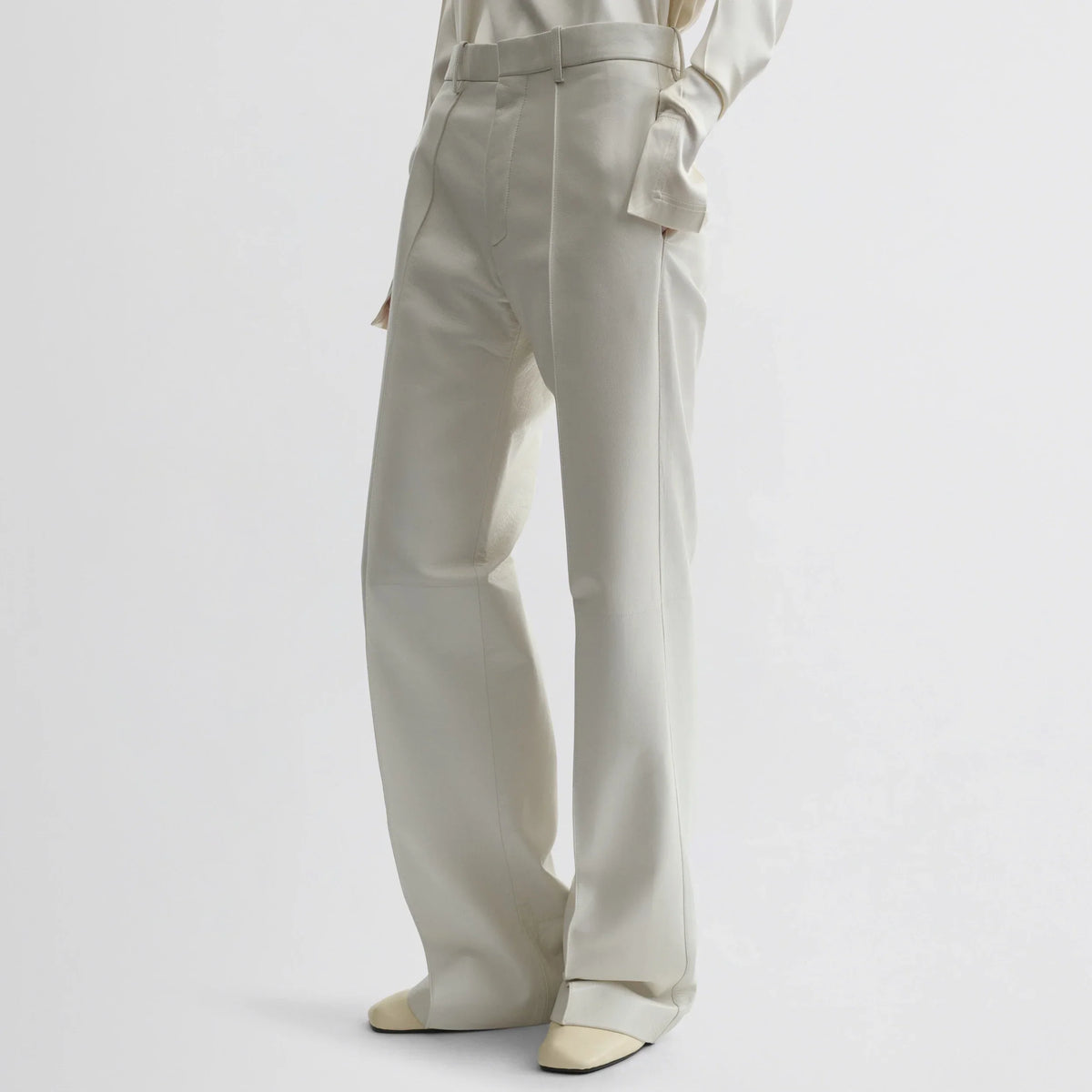 Front view of model wearing boyish trousers in white leather