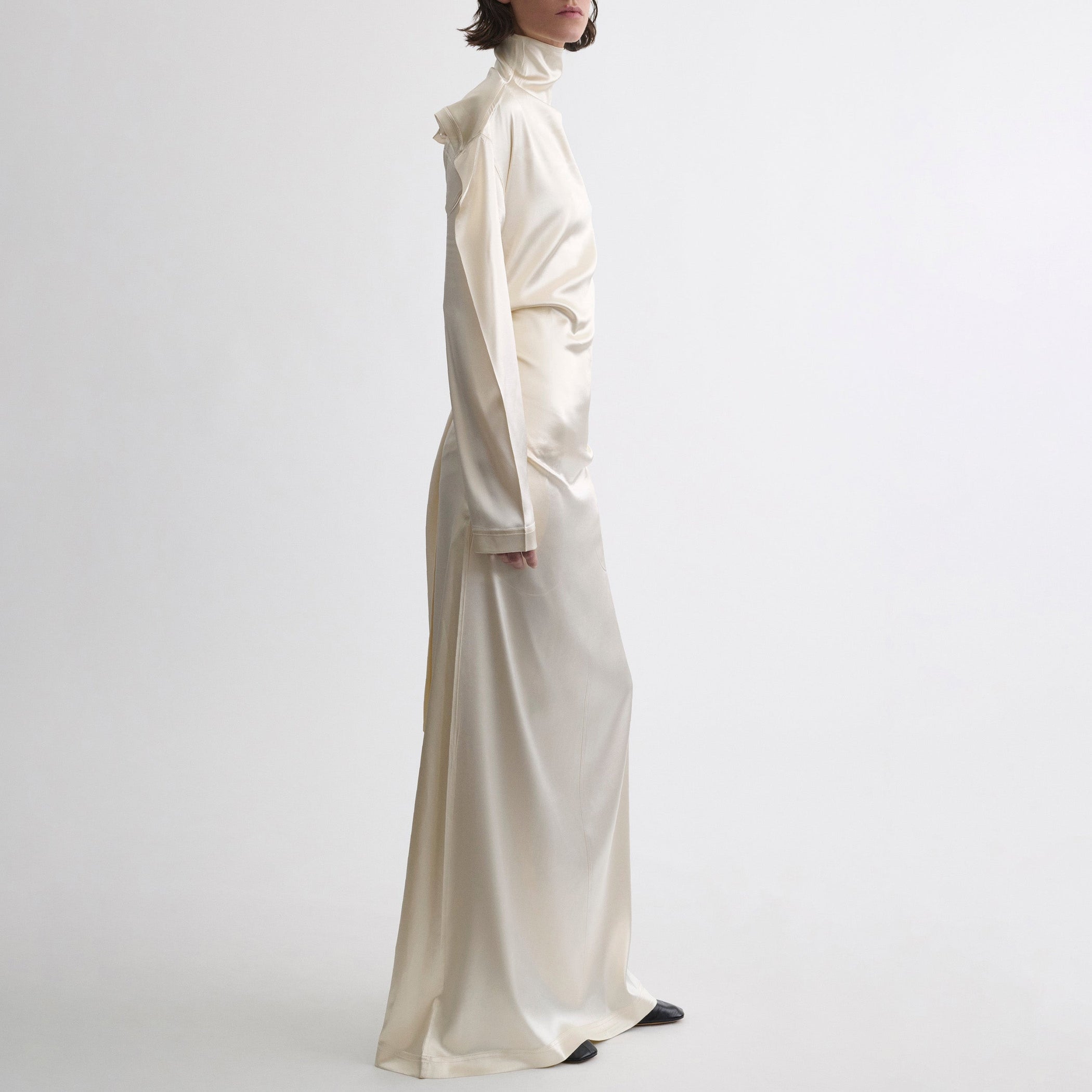 Side view of model wearing LIQUID OPEN BACK DRESS in cream silk satin