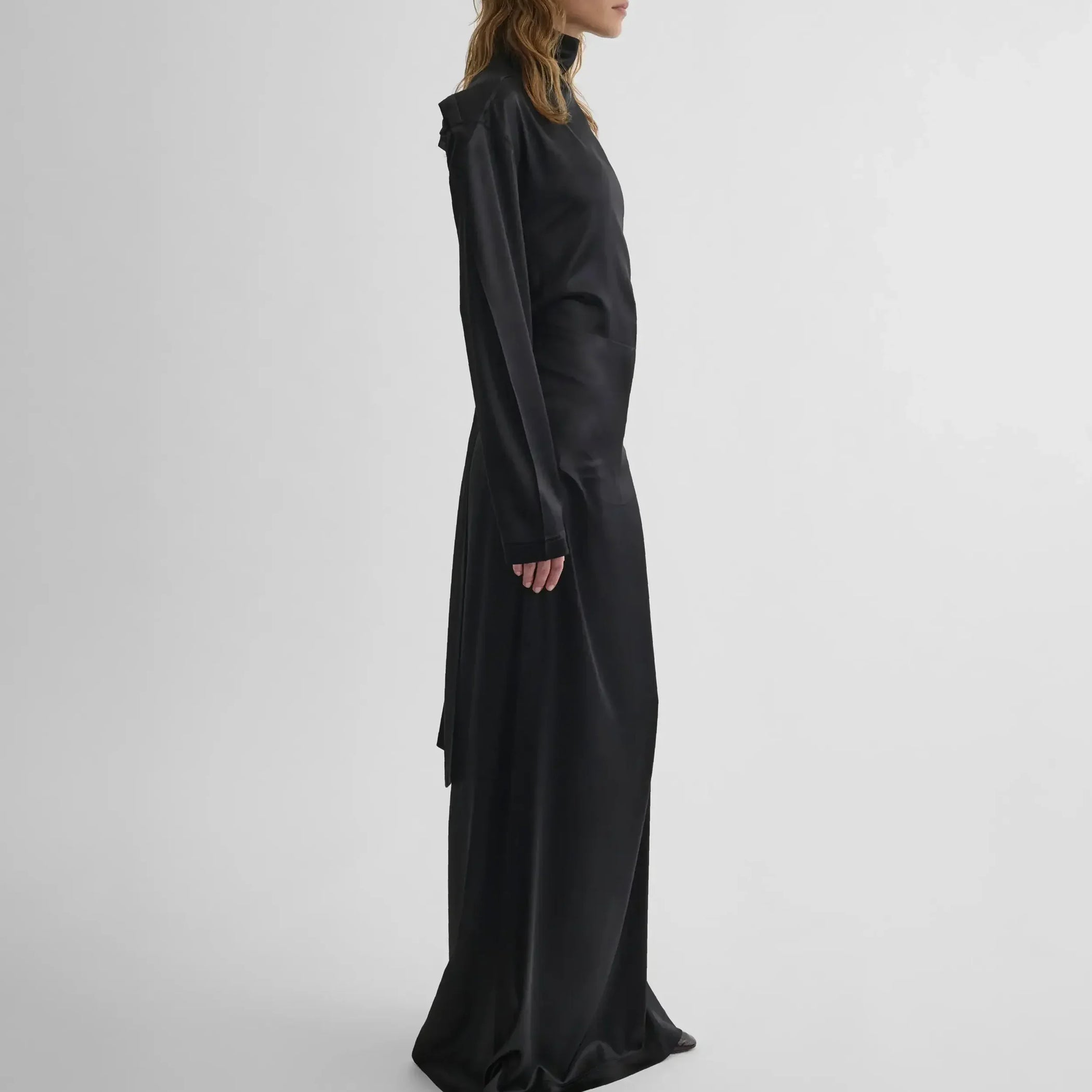 Side view of model wearing LIQUID OPEN BACK DRESS in black silk satin