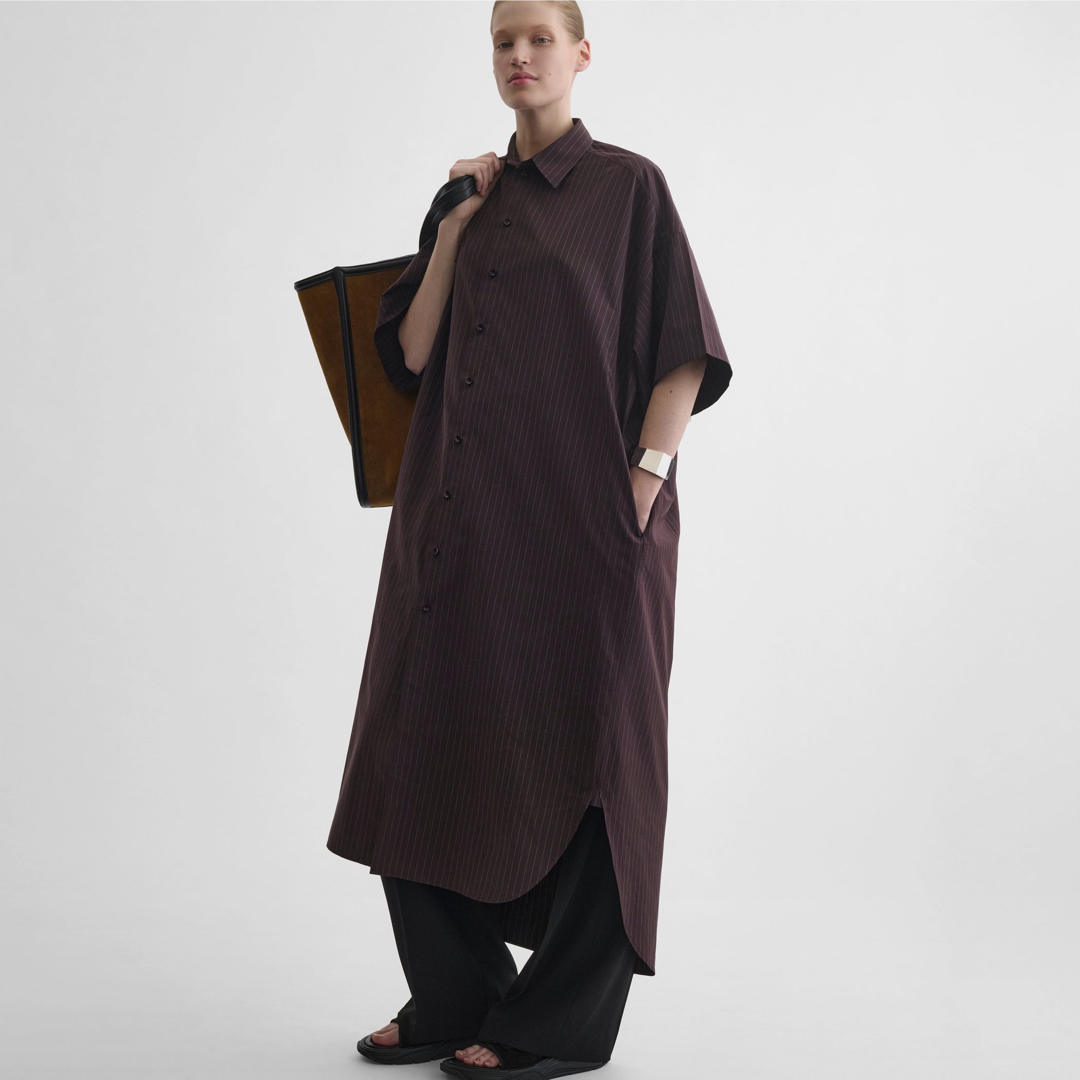 Angled front view of model wearing long shirt dress in black cherry cotton