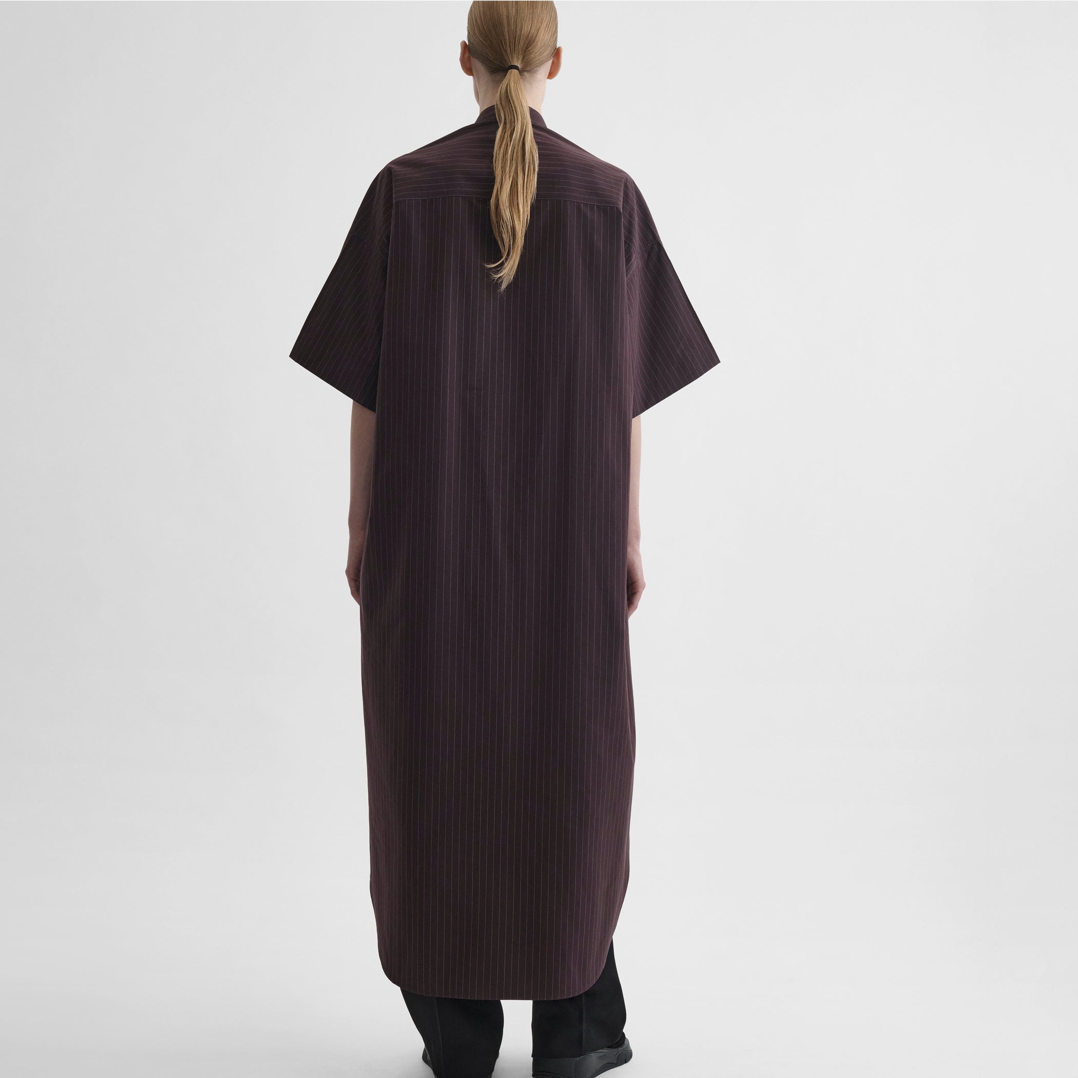Back full body view of model wearing long shirt dress in black cherry cotton