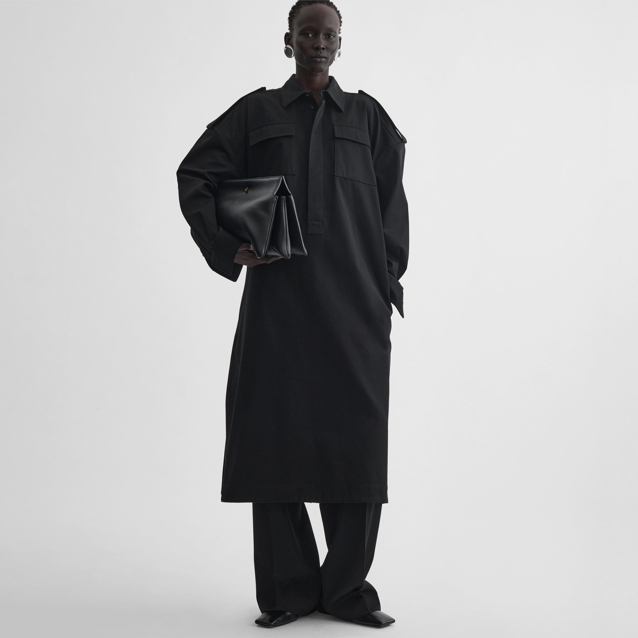 Front full body view of model wearing utility shirt dress in black cotton