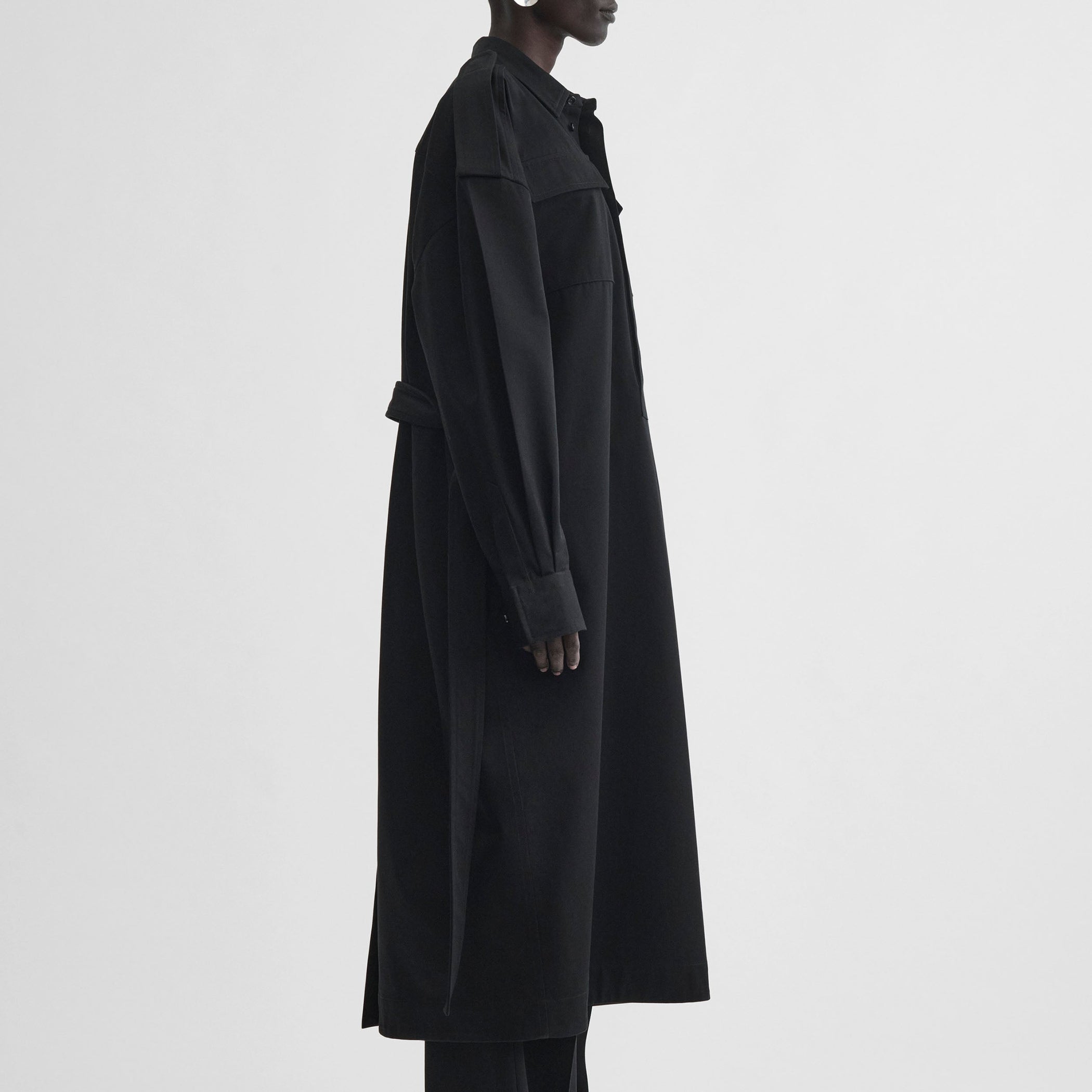 Side view of model wearing UTILITY SHIRT DRESS in black cotton