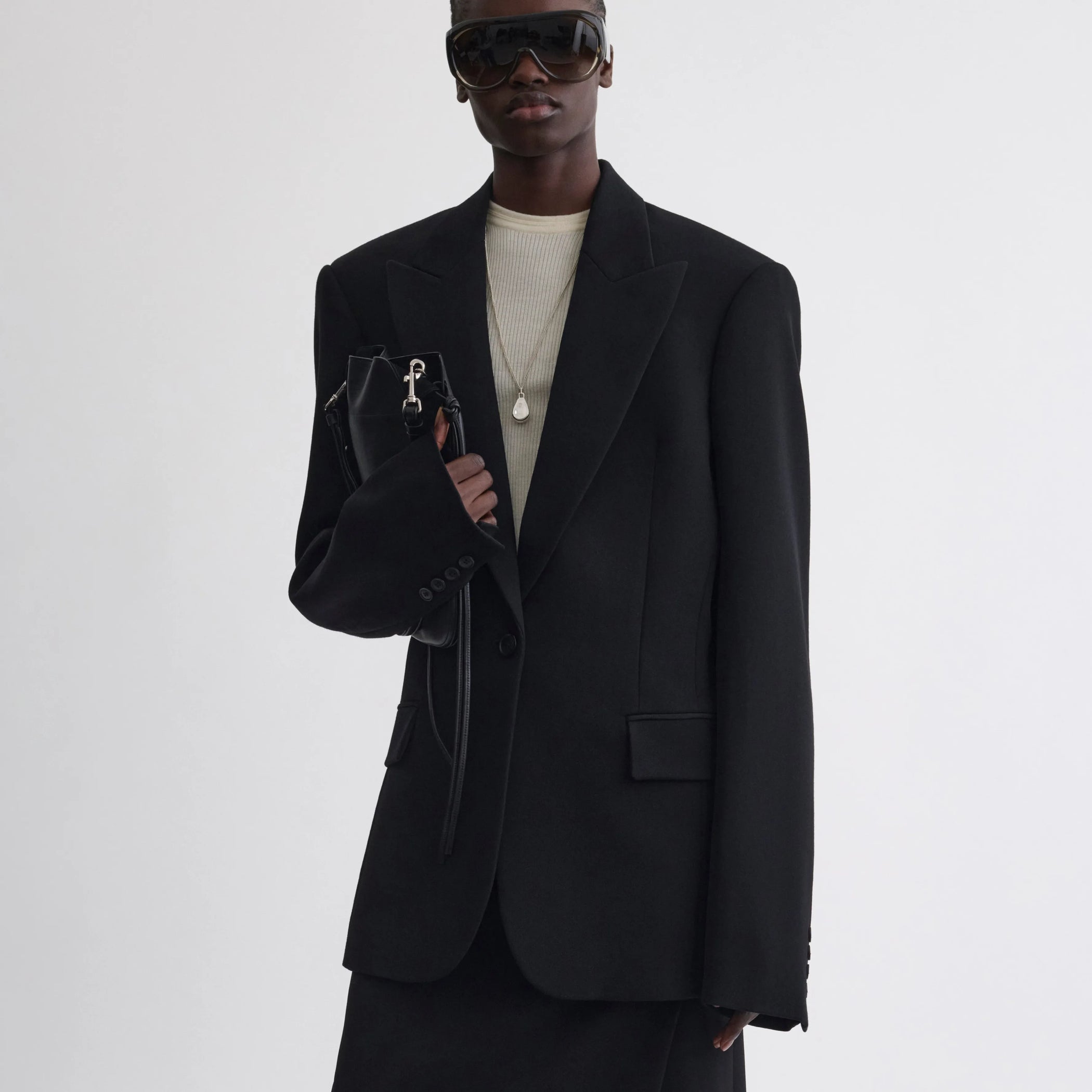 Front view of model wearing Single Breasted Tailored Jacket in black.