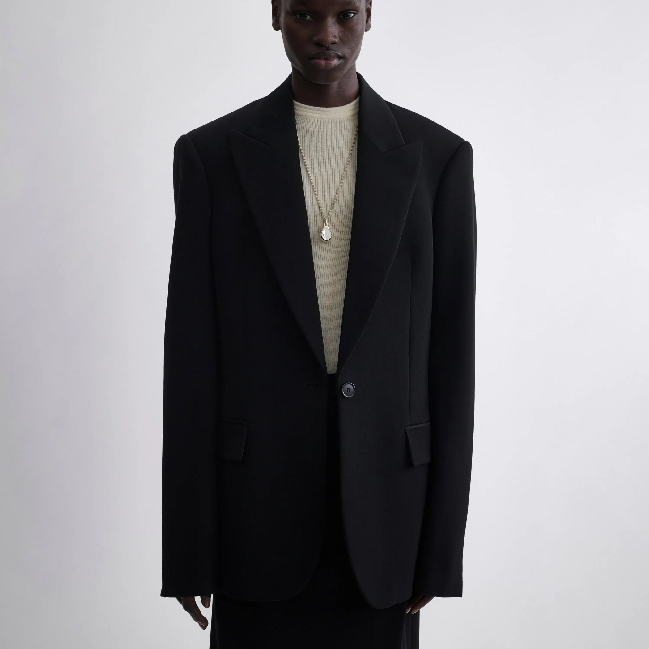 Front view of model wearing Single Breasted Tailored Jacket in black.
