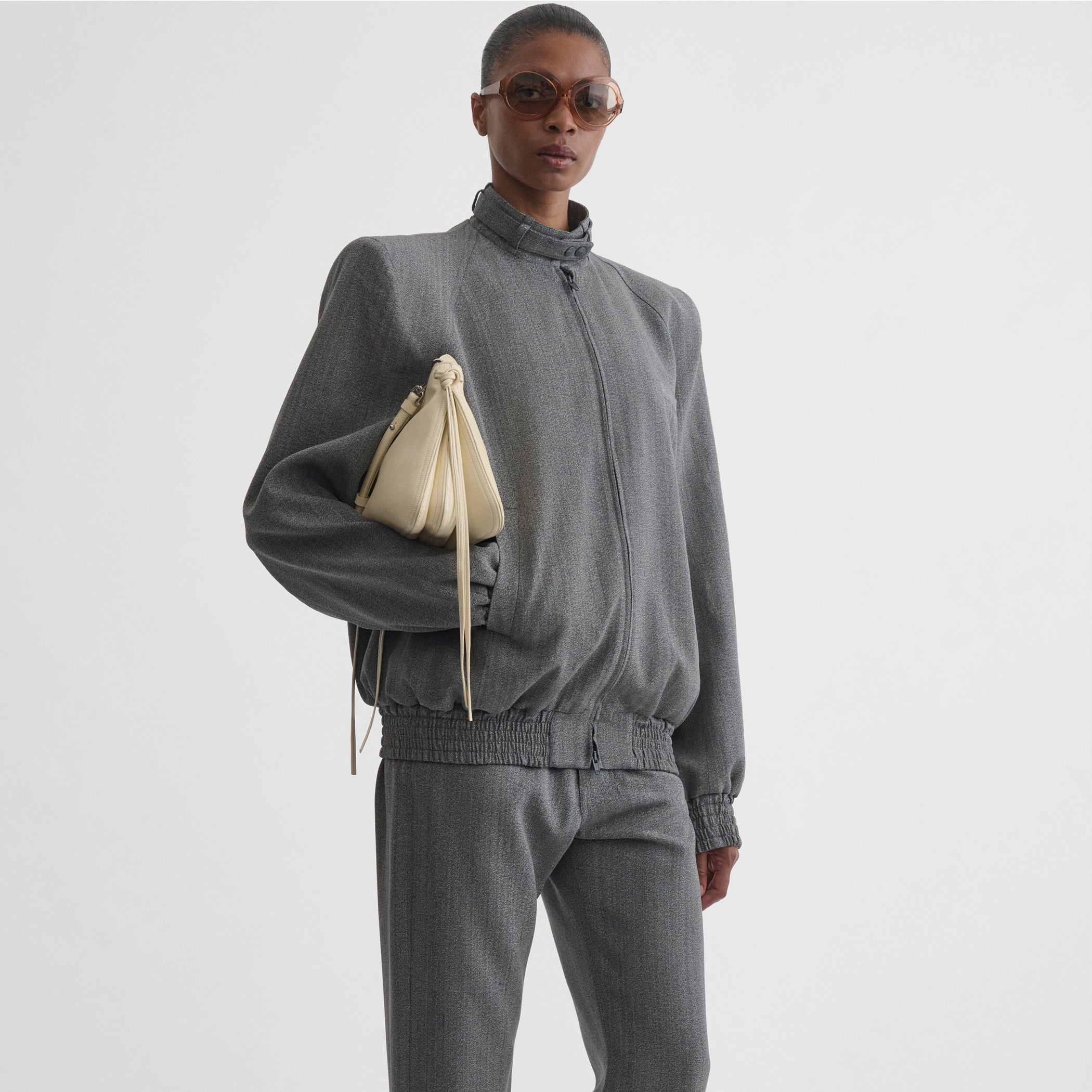Front view of model holding the small gig in stucco leather 
