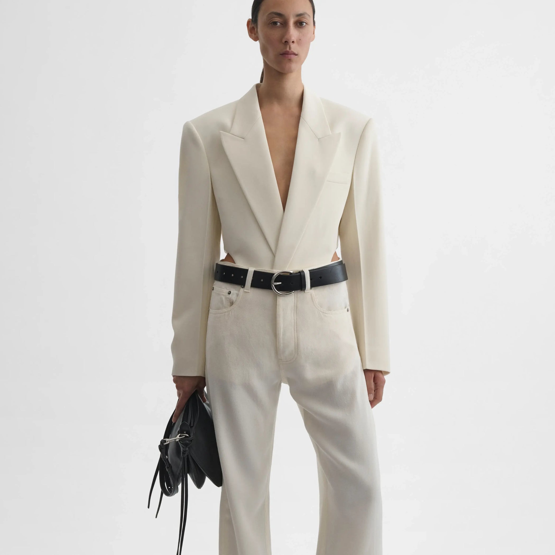 Front view of  model holding small gig in black leather 