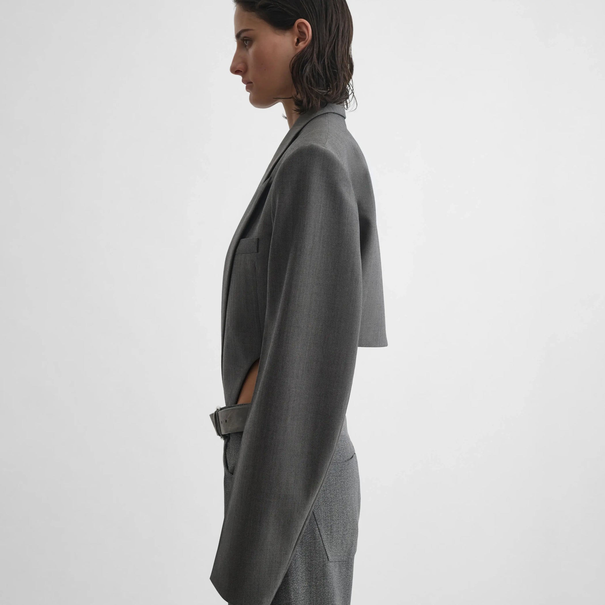 Side view of model wearing Tucked Tailored Jacket in dark taupe.
