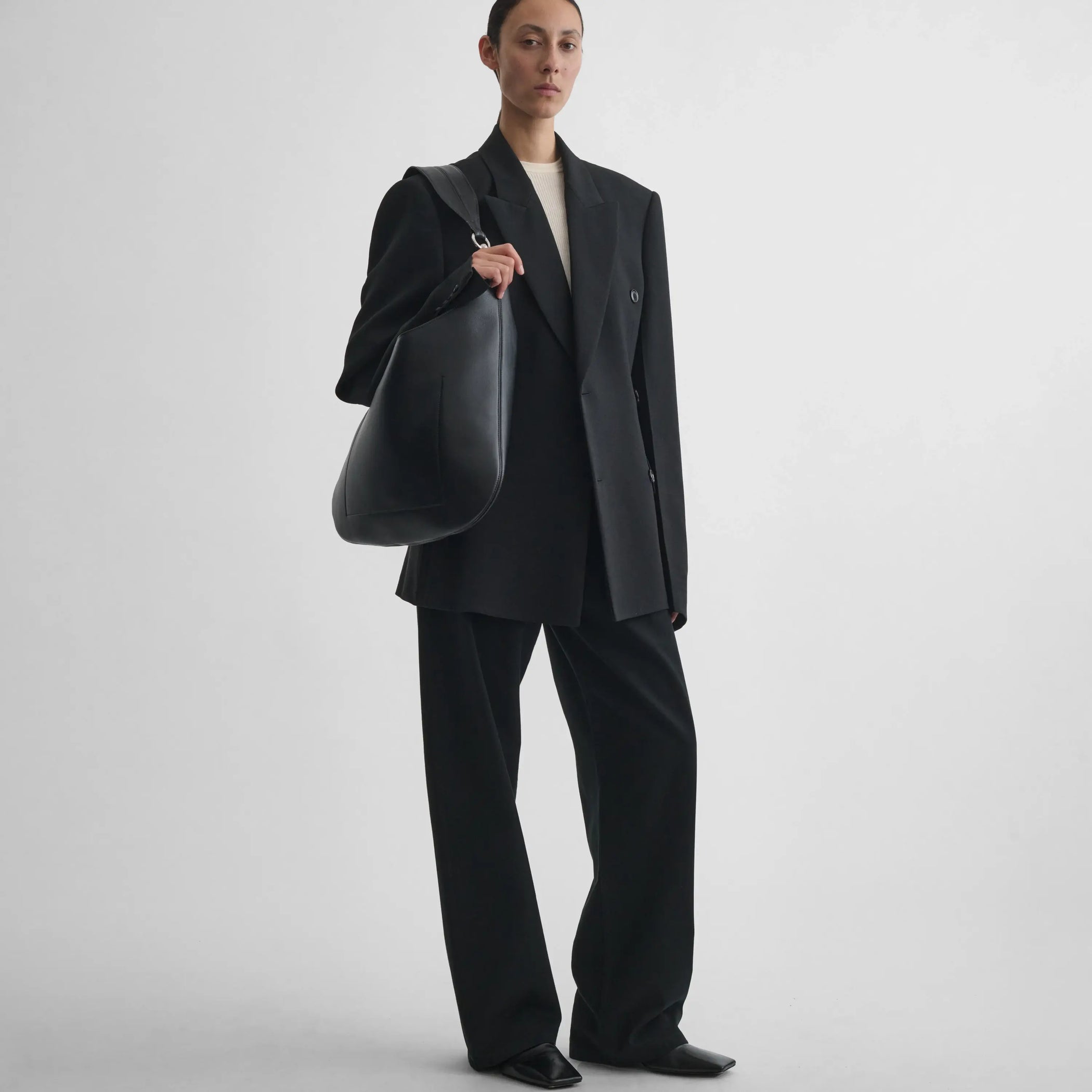 Full body front view of model wearing Cinched Hip Tailored Jacket in black.
