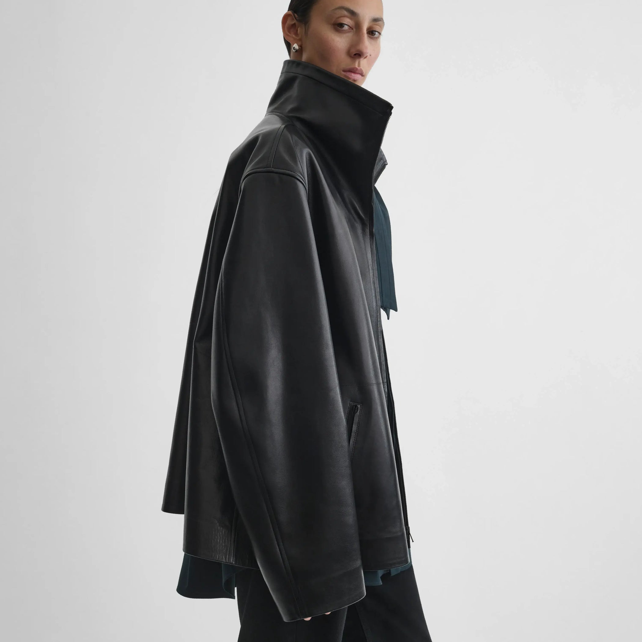 Side view of model wearing Funnel Jacket in black.