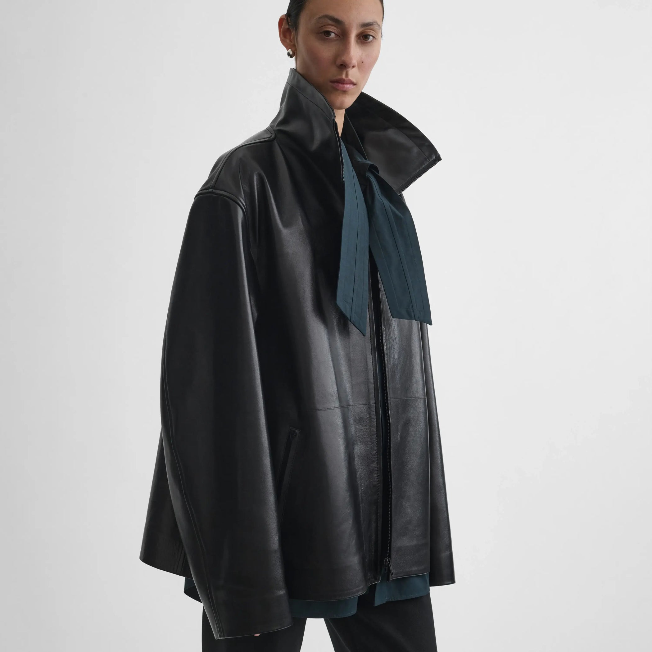 Angled view of model wearing Funnel Jacket in black.