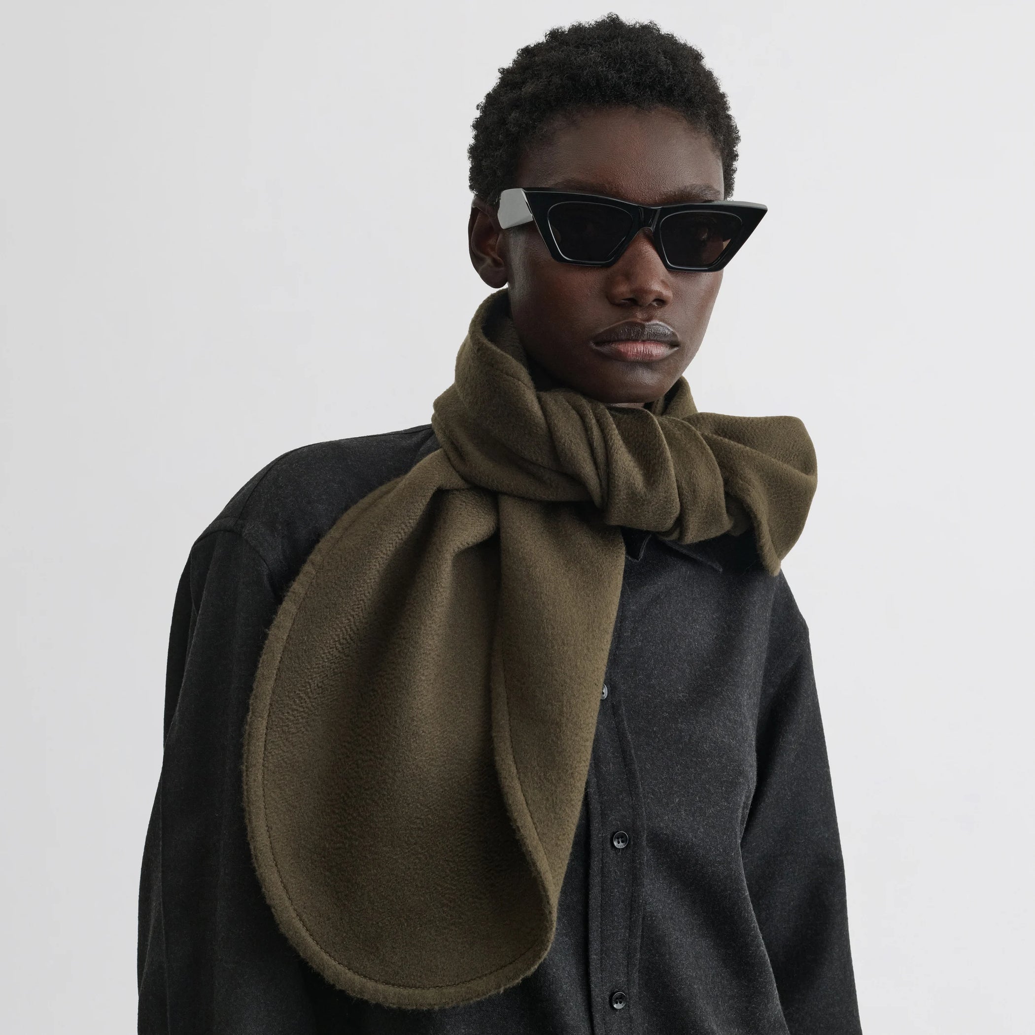 Front view of model wearing the dark double face scarf in dark khaki wool
