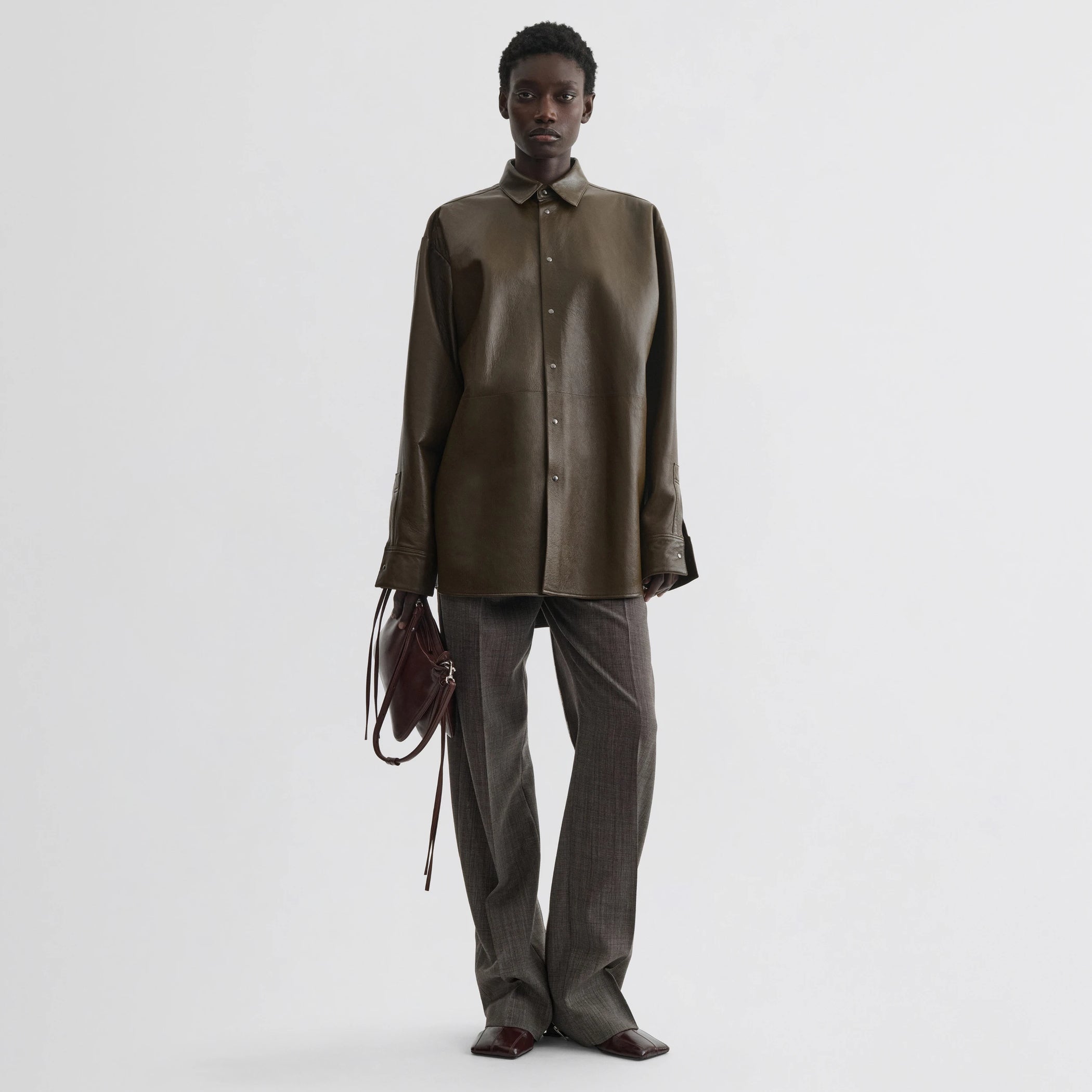 Front view of model wearing overshirt in green bronze leather.