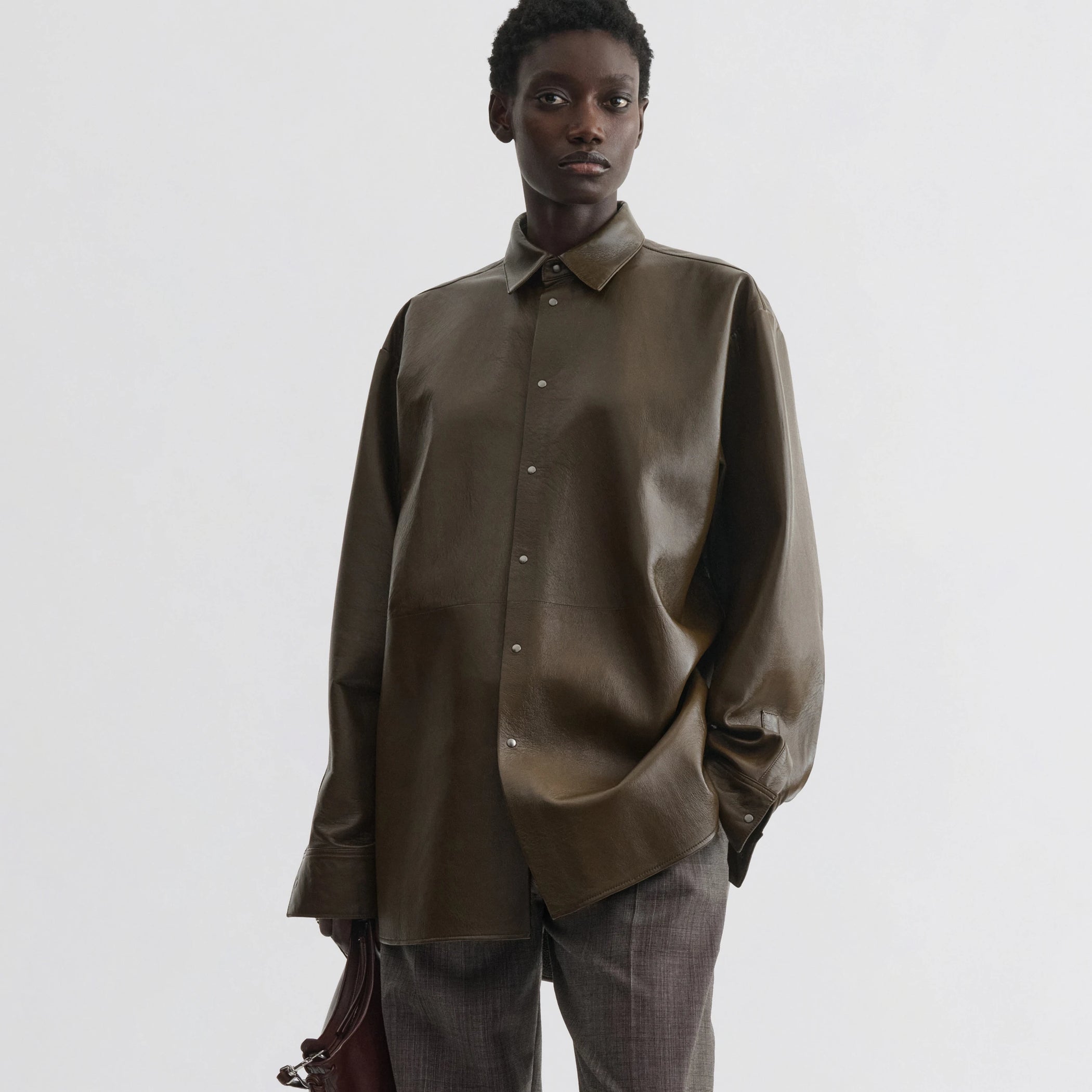 Front view of model wearing overshirt in green bronze leather.
