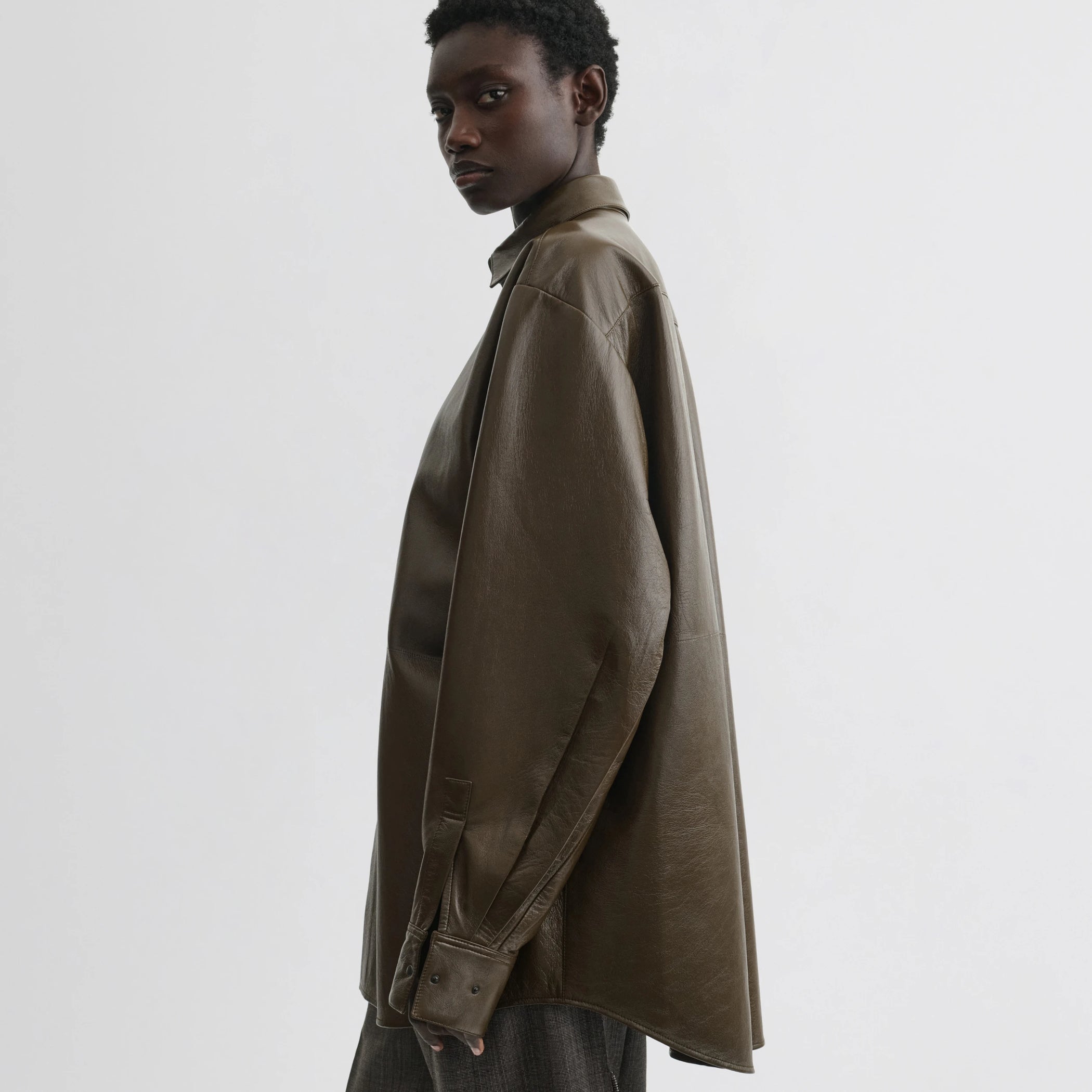 Side view of model wearing overshirt in green bronze leather.