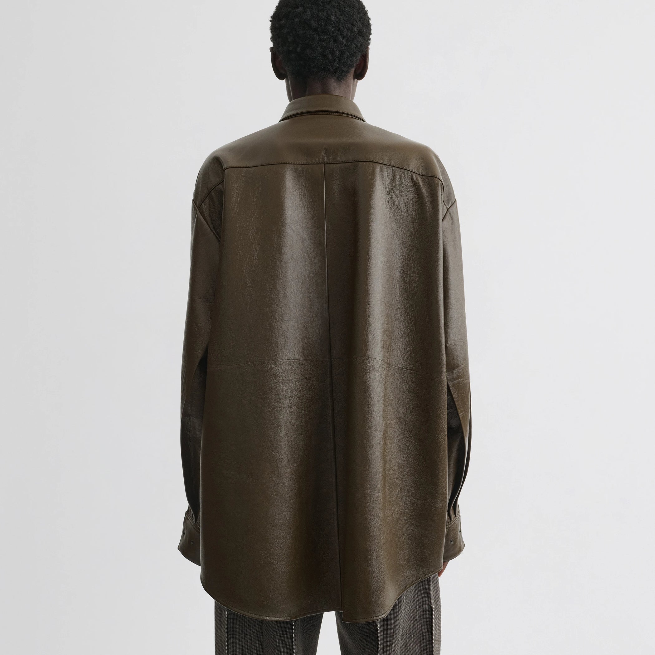 Back view of model wearing overshirt in green bronze leather.