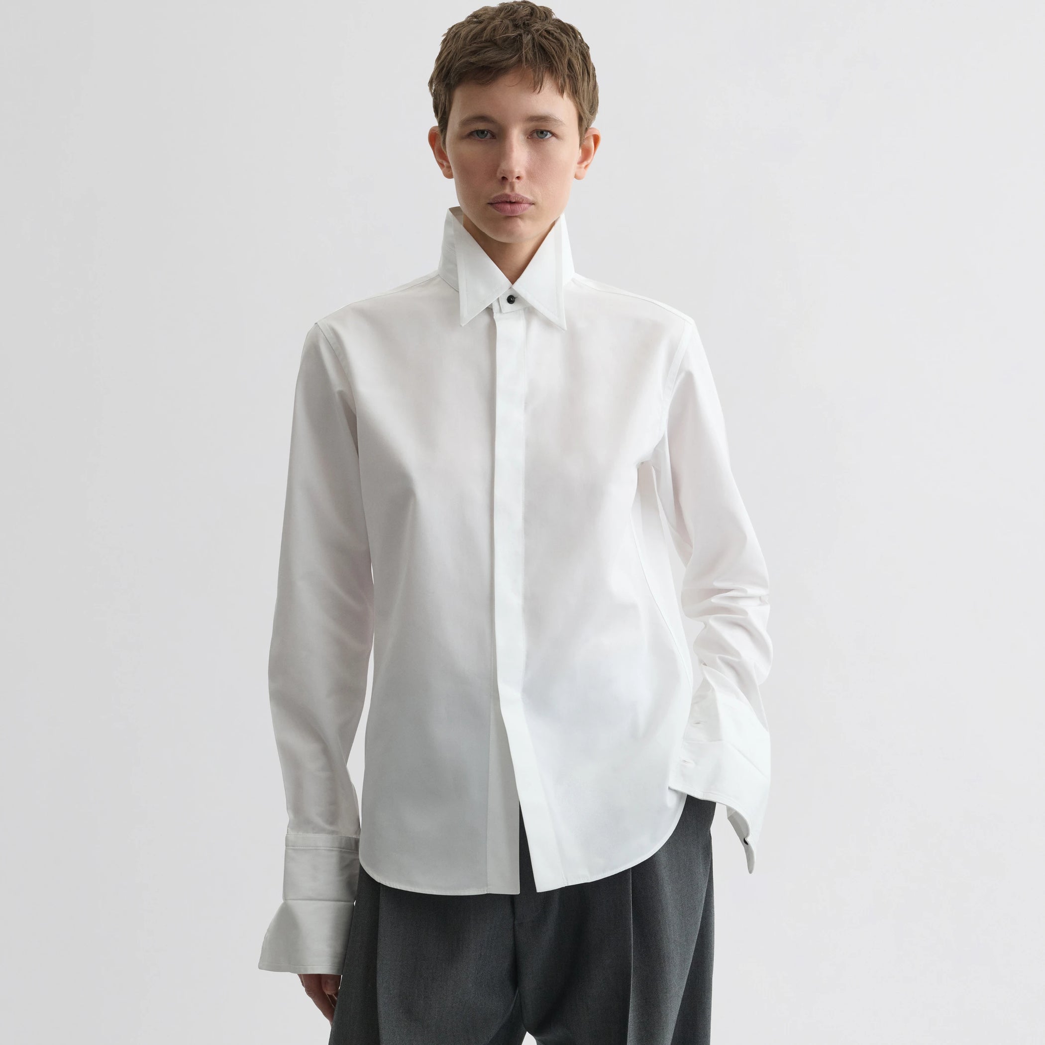 Front view of model wearing tuxedo shirt in white cotton.