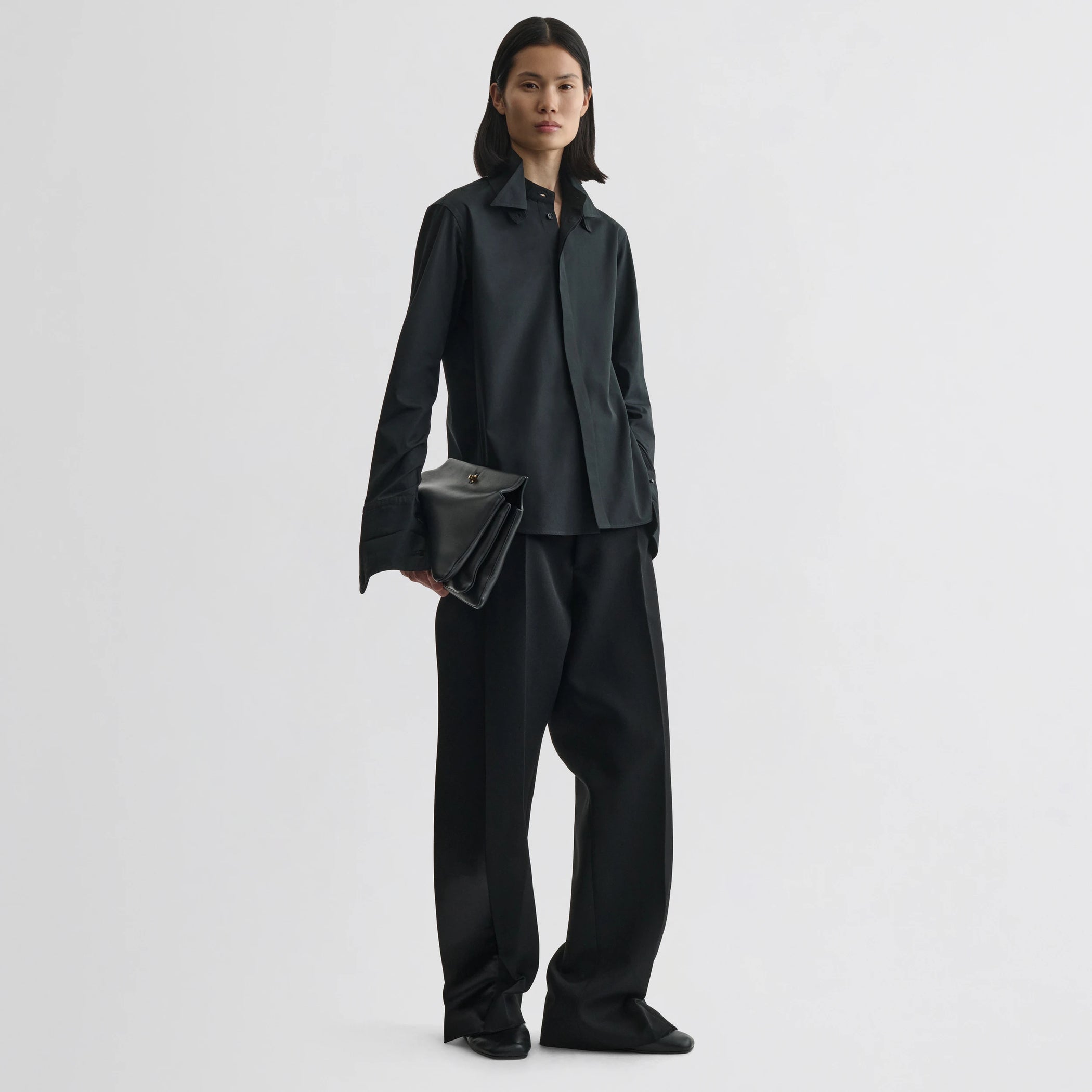 Front view of model wearing tuxedo shirt in black cotton.