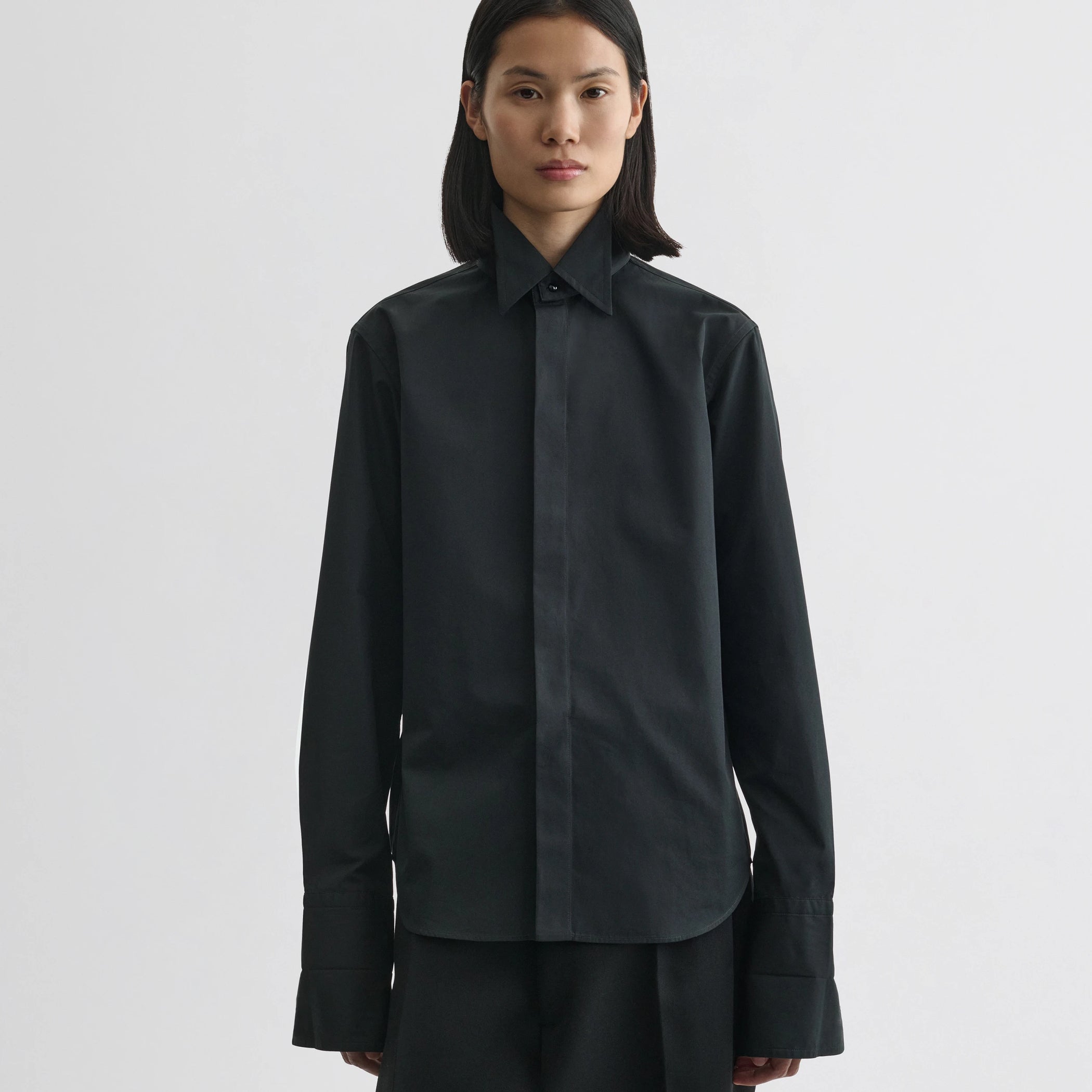 Front view of model wearing tuxedo shirt in black cotton.
