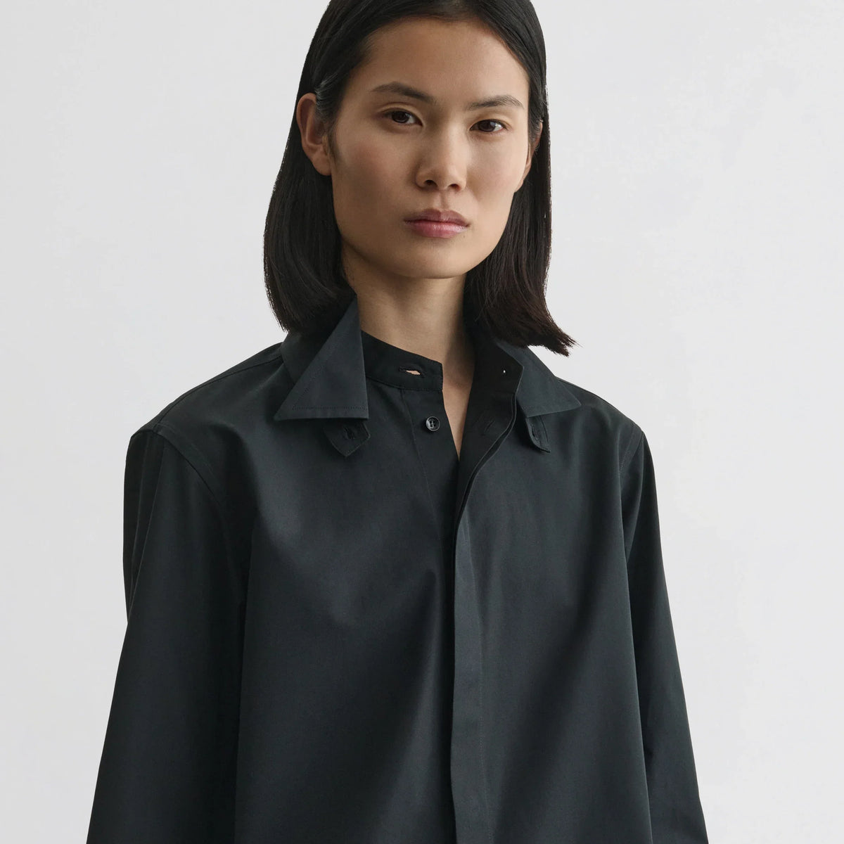 Front view of model wearing tuxedo shirt in black cotton.