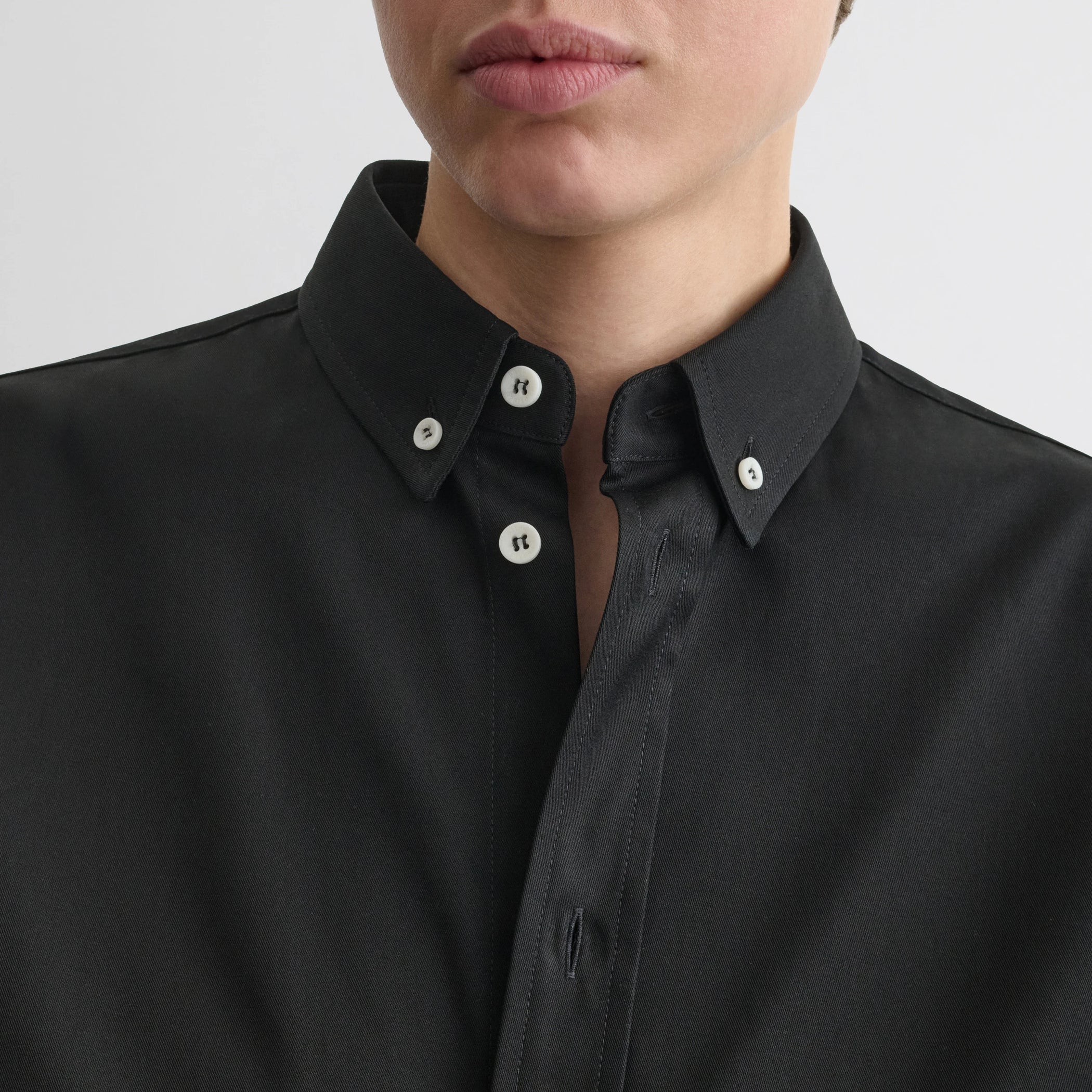 Close up detail view of button collar shirt in black cotton.