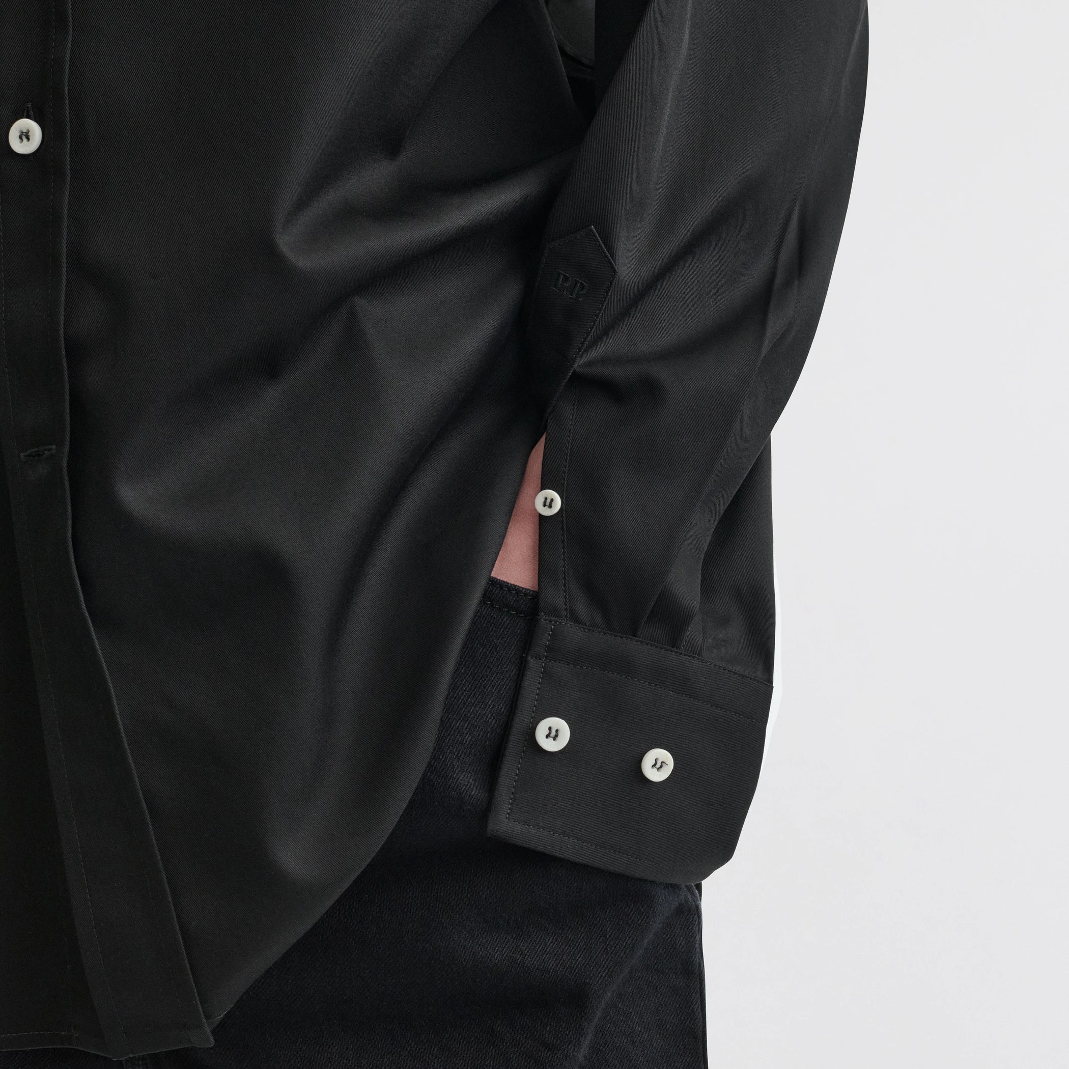 Close up detail view of button collar shirt in black cotton.