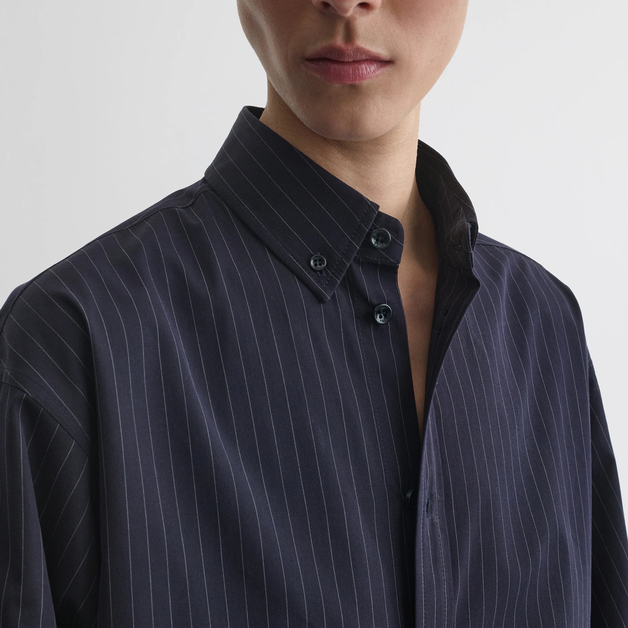 Close up detail view of button collar shirt in midnight pinstripe cotton.
