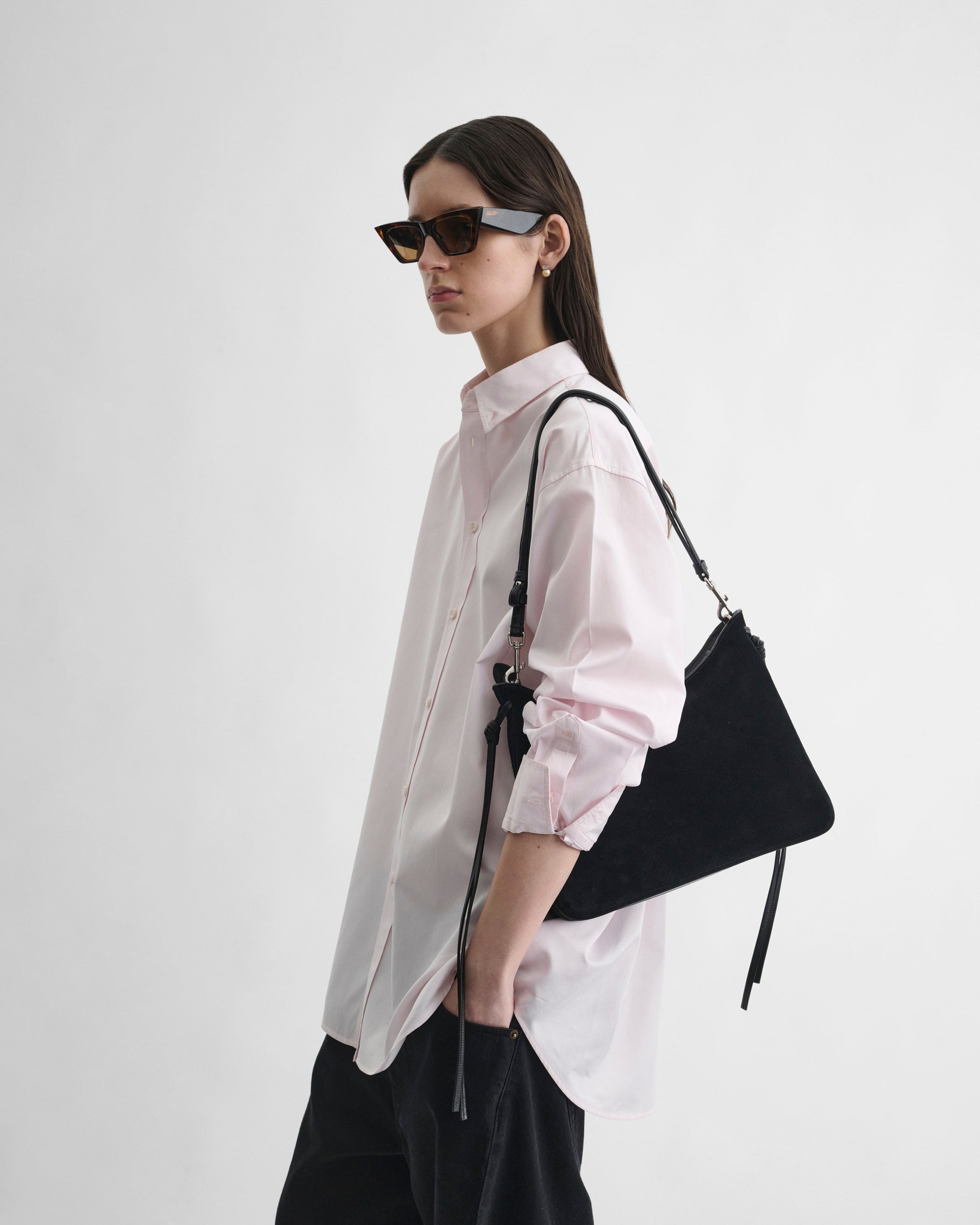 Side view of model wearing BUTTON COLLAR SHIRT in pale pink cotton
