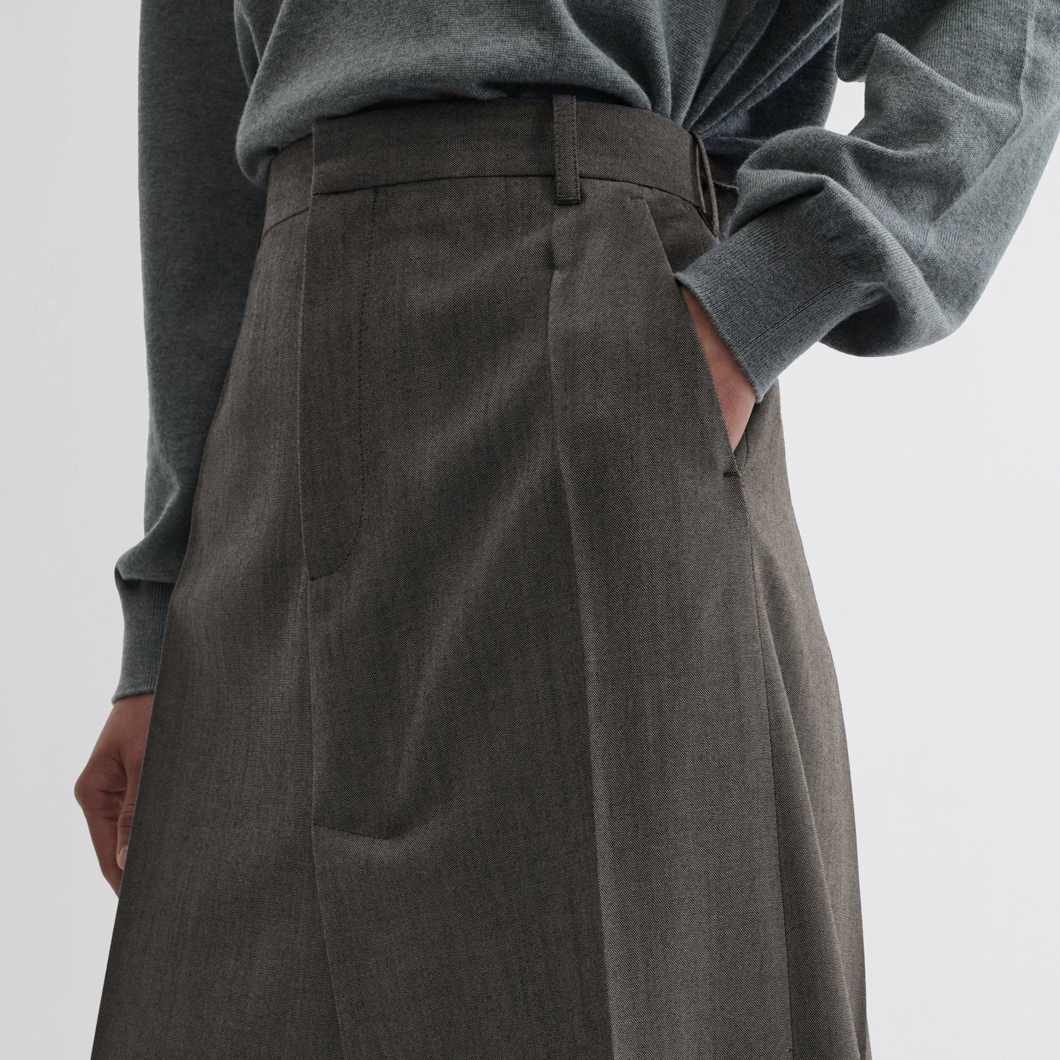 Close up detail view of double slit tailored skirt in dark taupe wool.