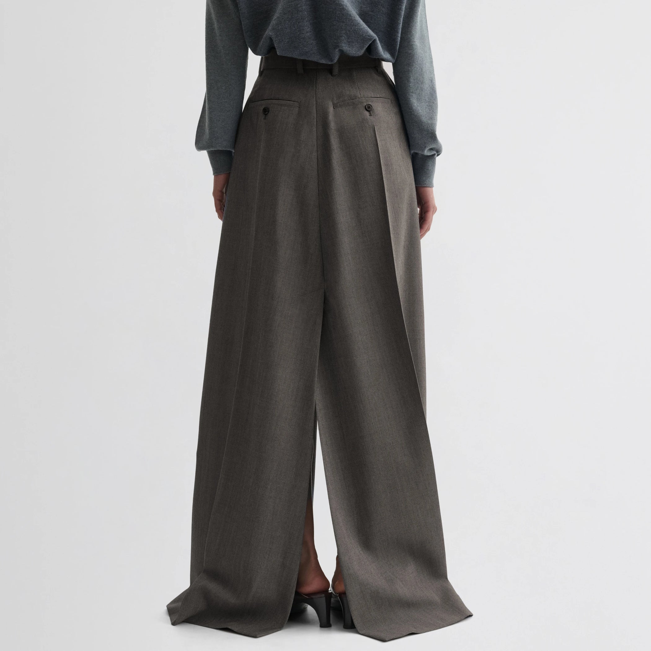 Back view of model wearing double slit tailored skirt in dark taupe wool.