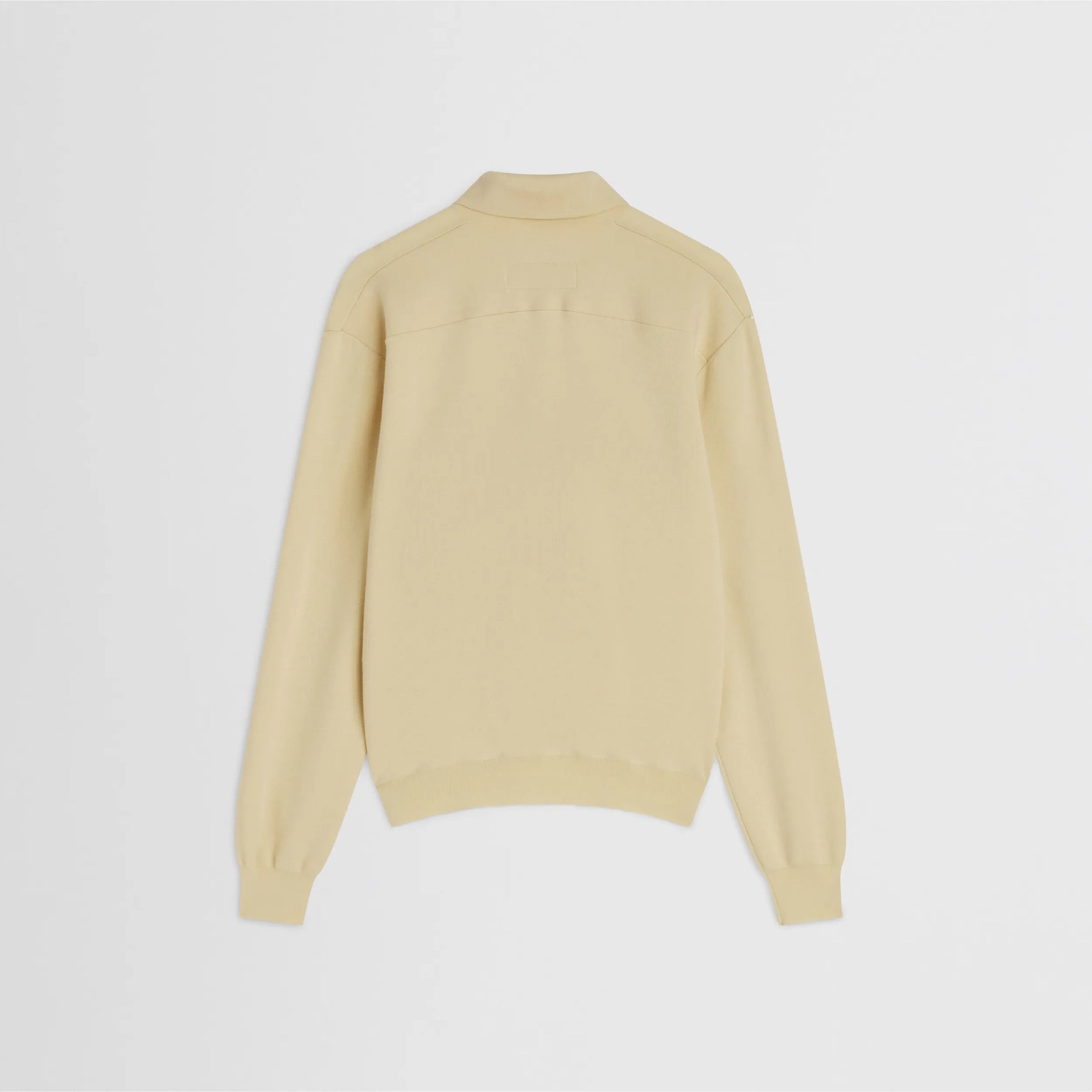 Flat back view of zip polo in pastel-yellow wool