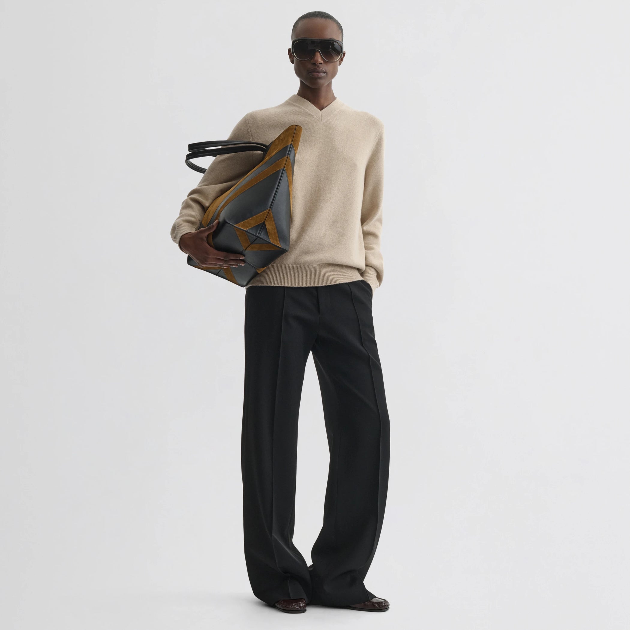 Front view of model wearing easy v-neck sweater in beige wool cashmere.
