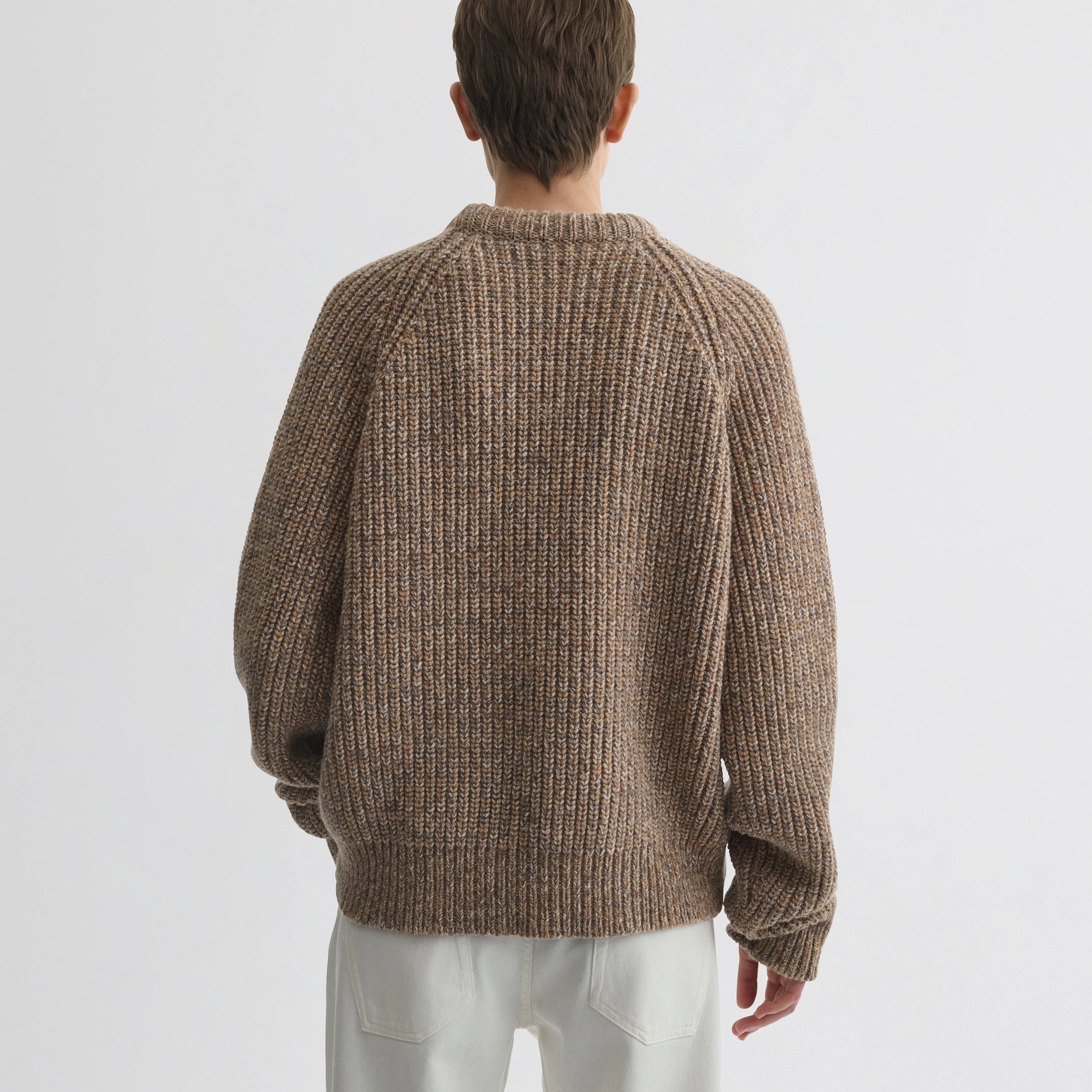 Back view of model wearing mouline jumper in camel wool.